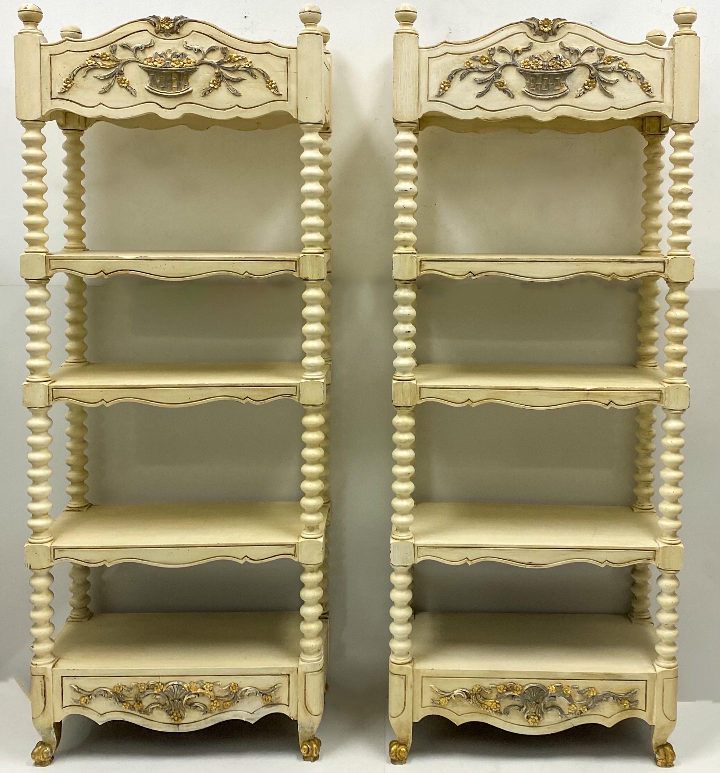 This is a pair of 1950s Maison Jansen French painted and carved étagères with spool supports. They are ivory with gray and gilt accents. They are stamped. From floor to shelves, the heights are as follows: 10.5”, 23”, 39.5”, 52”, 65.5” to the top