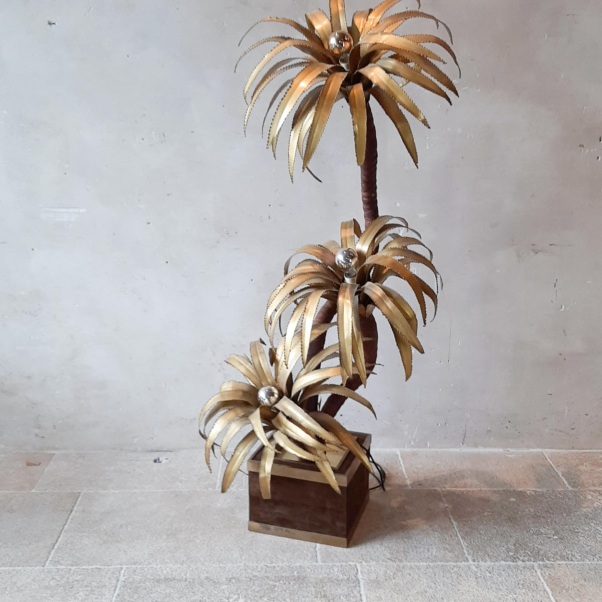 Midcentury Maison Jansen Palm tree lamp. A beautiful Hollywood regency style floor or large table lamp in the shape of a palm tree, with palm leafs. The golden, copper coloured brass leafs of the palms reflect a warm atmospherical light into the