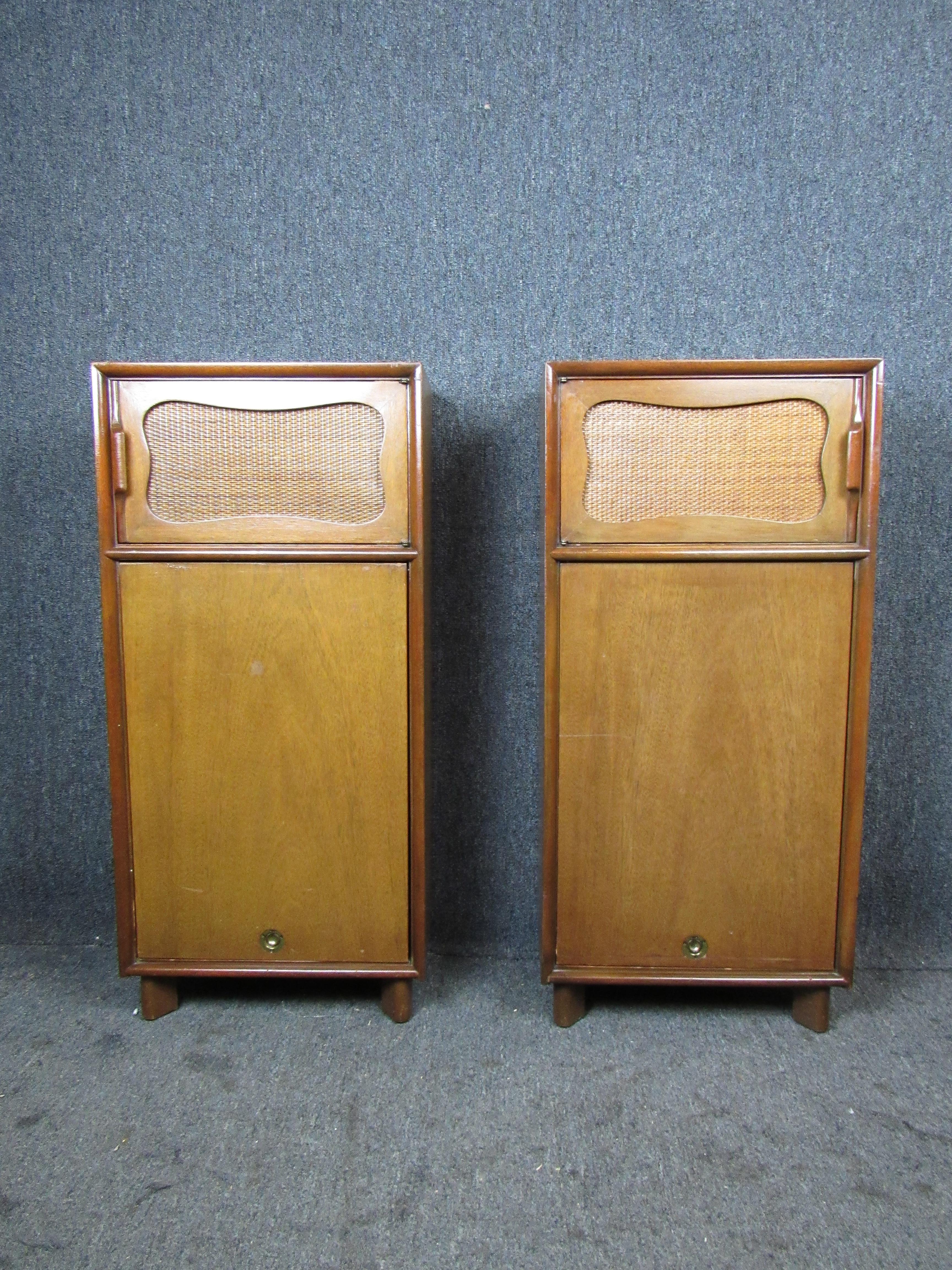 Here's a fantastic pair of vintage Mid-Century Modern nightstands! Featuring an unusual, elongated profile, rattan adornments, and a unique top-down sliding door. Rich mahogany wood grain lends a touch of class to a wide variety of decor styles.