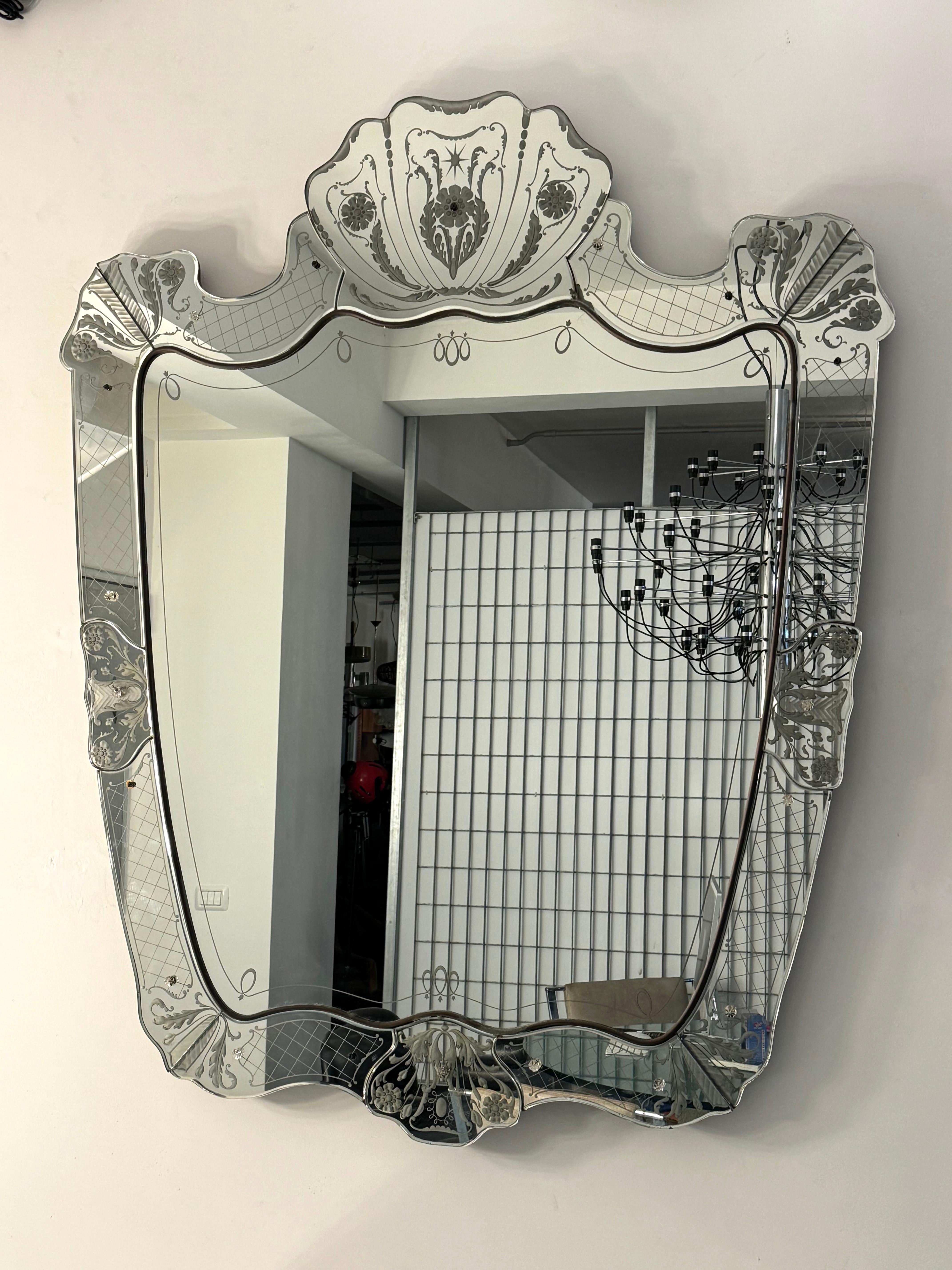 Remarkable Pietro Chiesa manner, large Venetian mirror produced in Italy during the 40s. Moled edge glass and details in brass. The back is in thick wood. To be noticed that the condition are unaltered and there are some small glass screw covers