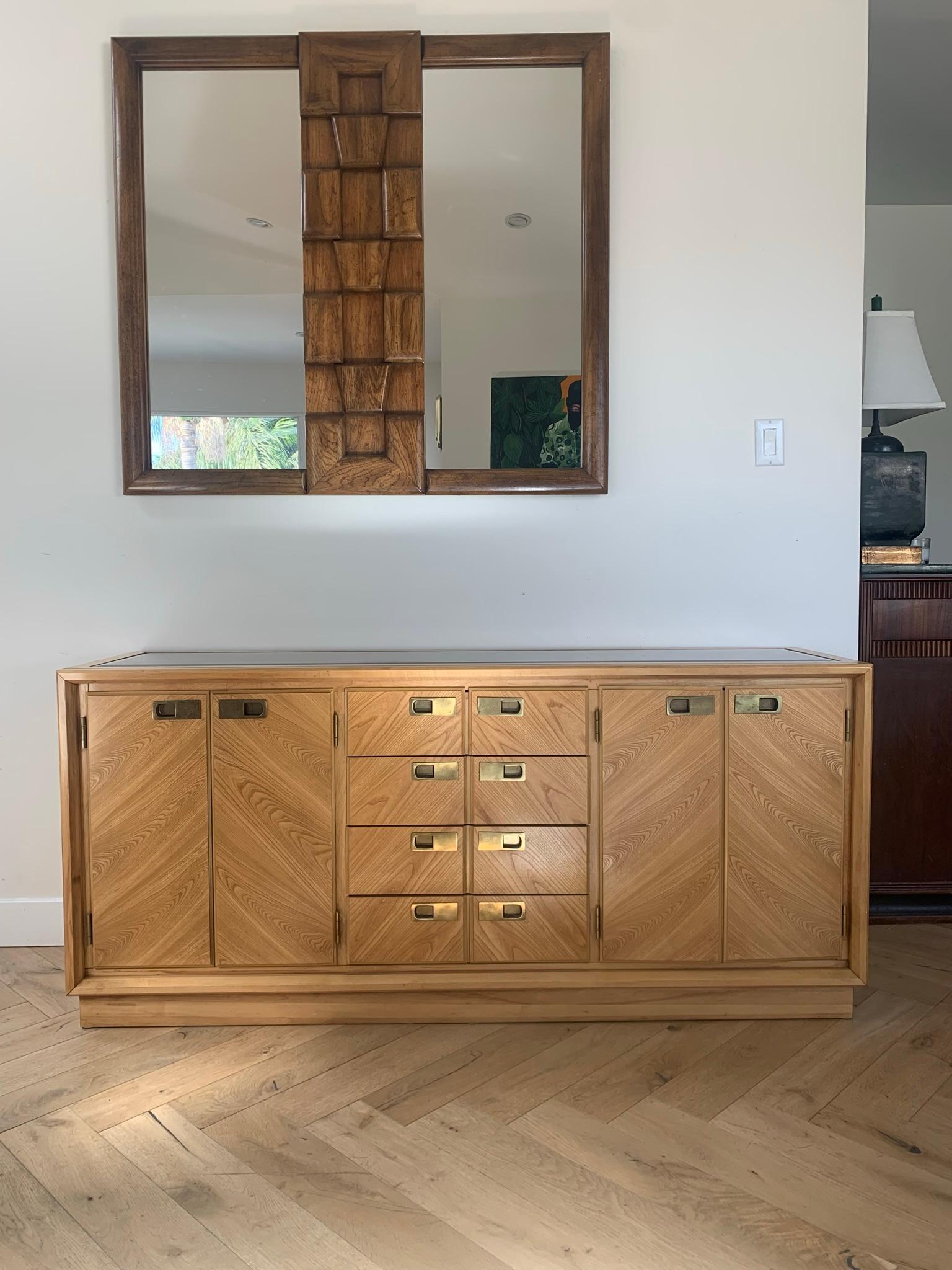 A statement sideboard in an exquisitely-grained blonde maple wood with smoked glass inlay by Stanley, circa late 70s. Danish style metallic hardware is original to the piece. Quite immaculate condition with minor signs of age (shown in close-up I’m