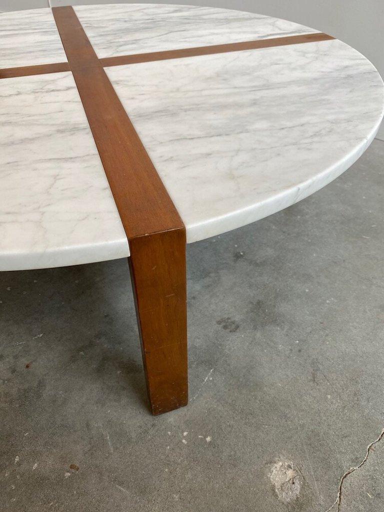 A recently refurbished mid century marble and walnut coffee table attributed to Tommi Parzinger. 42” Round, the top of the table is divided by triangular marble pieces with an inlaid walnut frame.