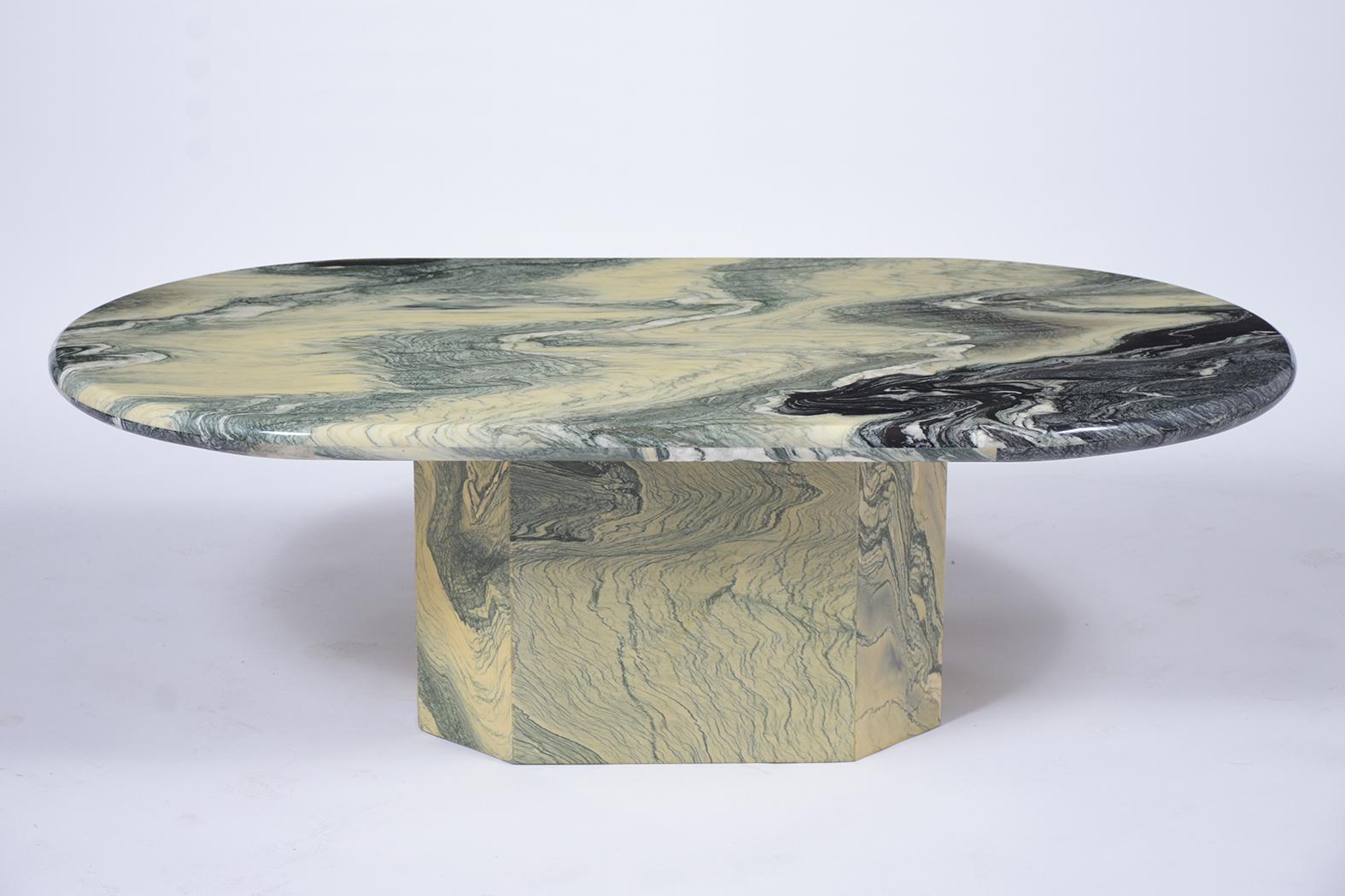 An Exceptional Italian Low Coffee Table handcrafted out of marble is in great condition. This fabulous piece features a beautiful wave pattern of dark green and light color, a unique oval top cocktail table, and sits on a sturdy octagonal base. This