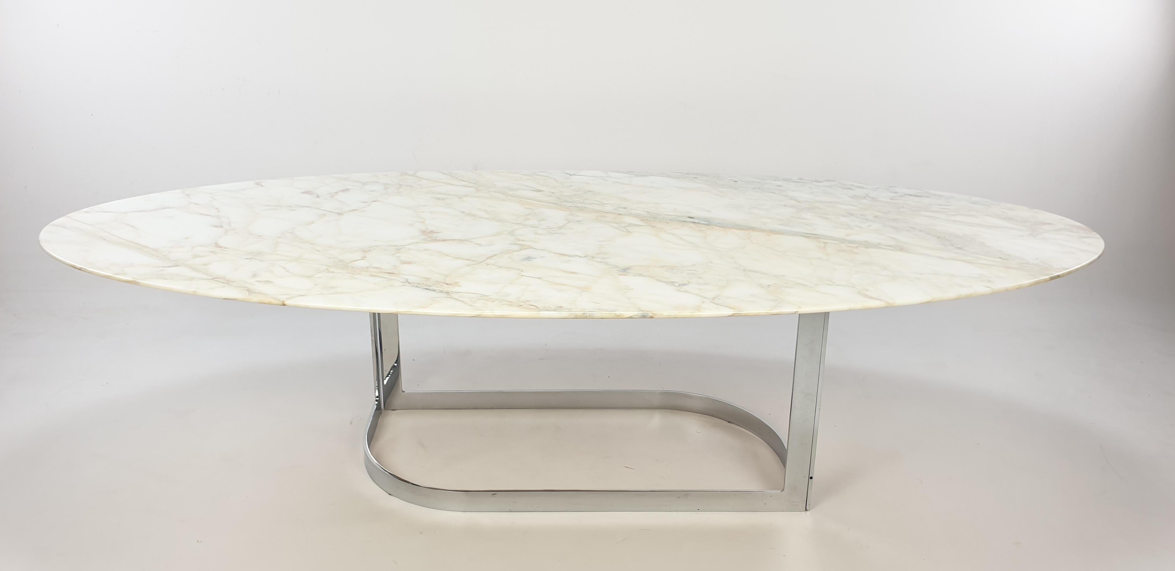 Stunning oval coffee table from the 70's, fabricated by Roche Bobois. It has a very beautiful and large marble plate and a elegant chrome foot. The plate is polished and it is in very good condition.