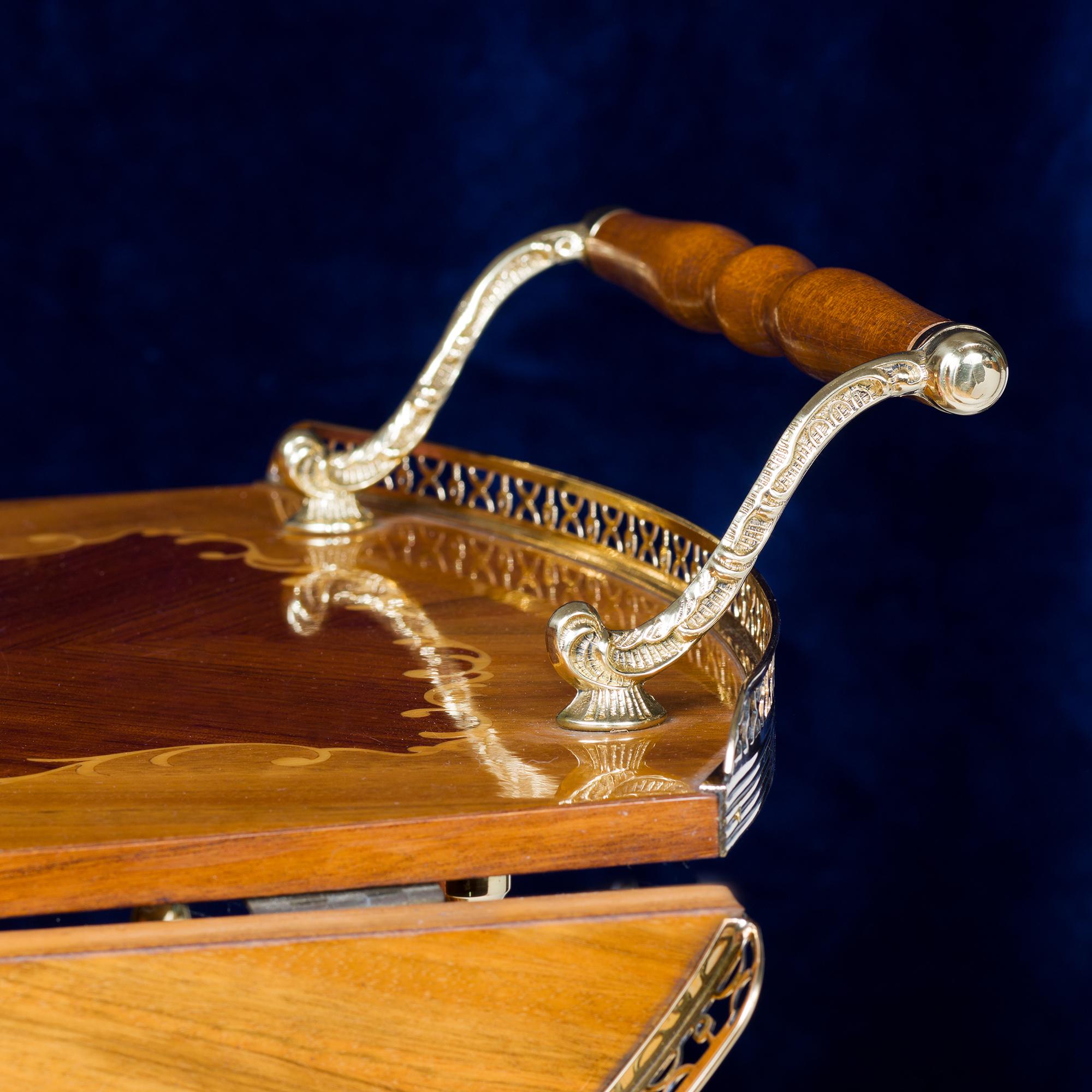 Mid-20th-century polished brass drop leaf bar cart with hand-turned wheels and supports, marquetry tops to top and bottom with triple bottle holders.
Italy, circa 1950

Height of handle 70.5cm
Height of tray 62cm
Length of Trolley 86cm
Length