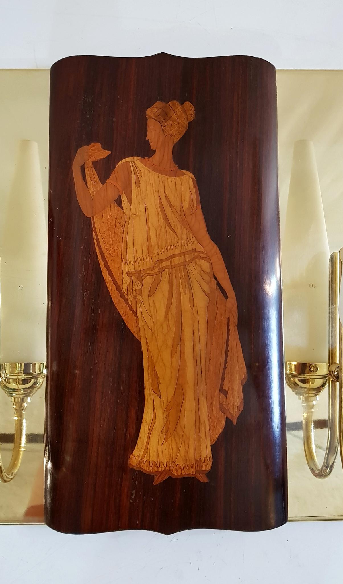 These particular wall sconces in brass was custom designed and made by a local artisan to hold the beautiful marquetry panels by Andrea Gusmai of Trani, Italy. The panels are produced in teak and boxwood depicting the Greek mythological gods Apollo