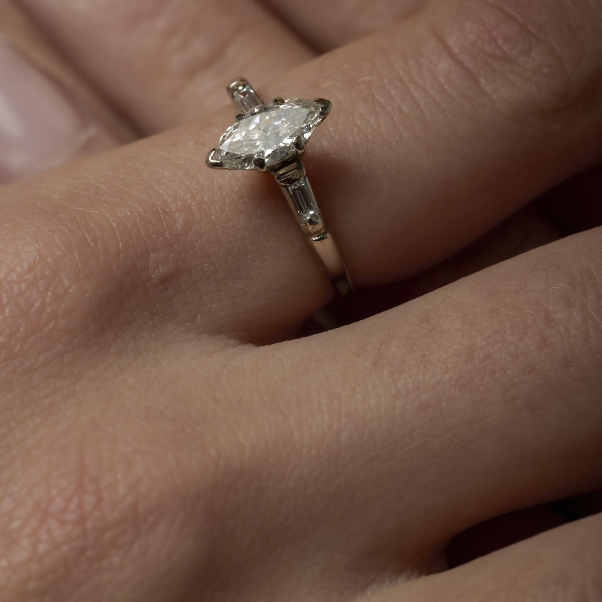 Gracieuse bague du milieu du siècle en or blanc 14k, centrée sur un diamant marquise de 0,60 carat, accentué par deux diamants baguettes étincelants de couleur F-G et de pureté VS.