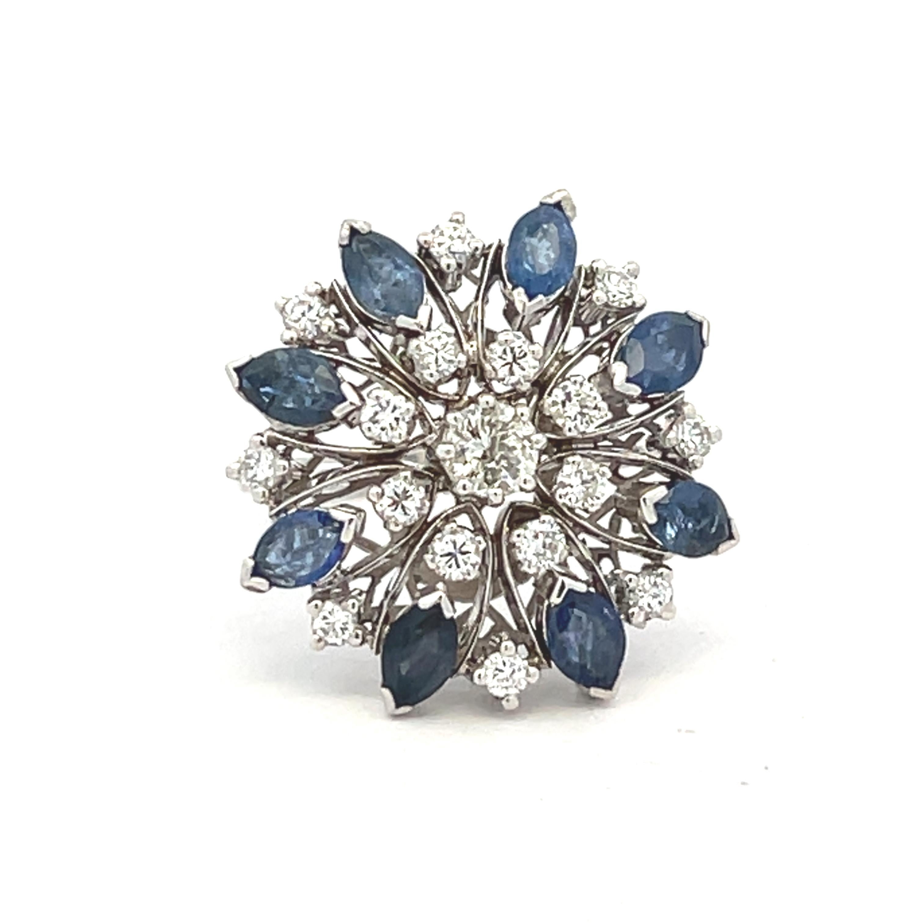 Deslumbrante expresión del glamour de mediados de siglo, este atrevido anillo de cóctel está elaborado en oro blanco de 18 quilates y diseñado con un motivo floral en forma de estrella, popular en los años 50-60. En su centro, un brillante diamante