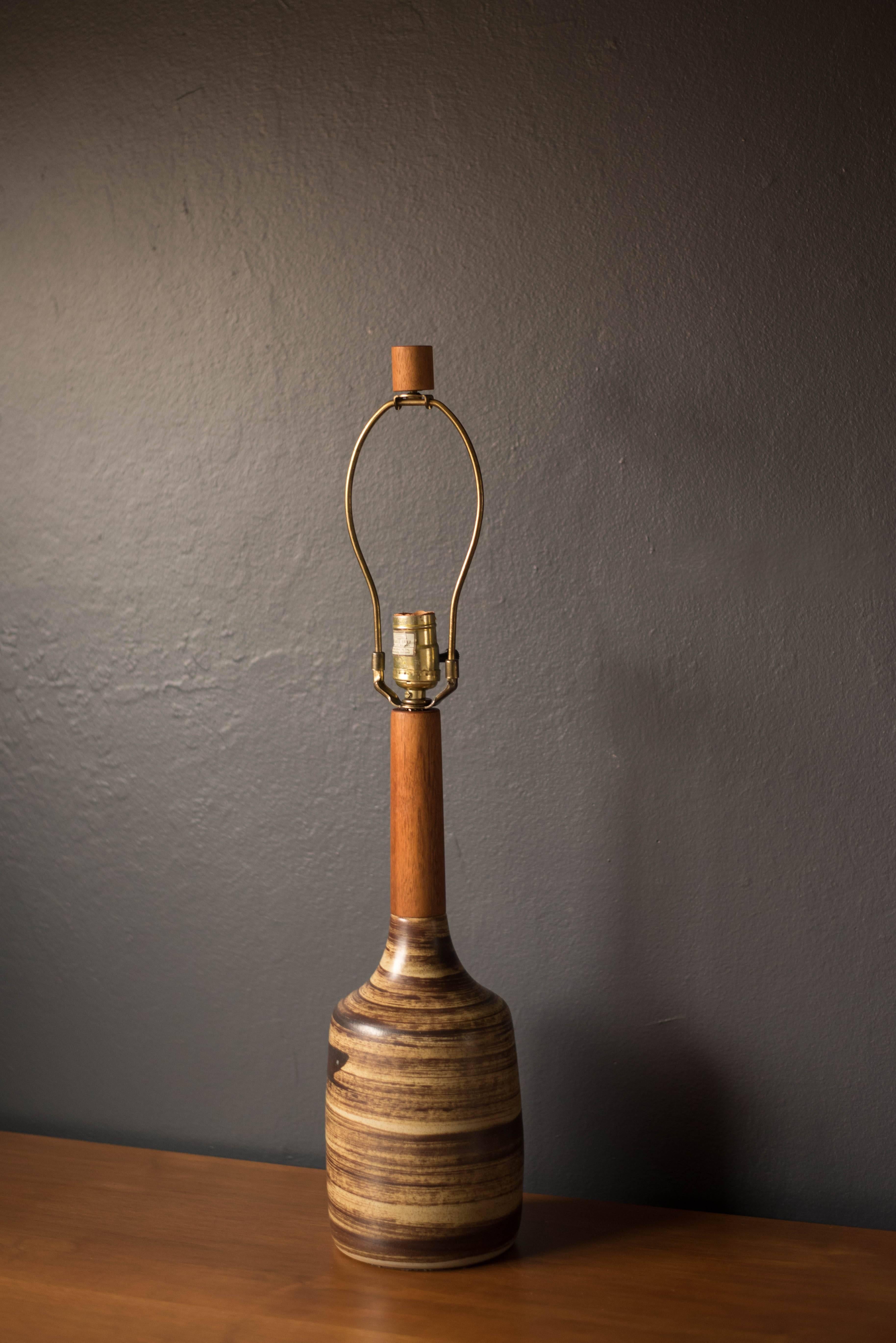 Mid-century ceramic lamp designed by Jane and Gordon Martz for Marshall Studios. This piece displays a textural neutral tone finish complete with the signature walnut finial. Shade is not included.
  