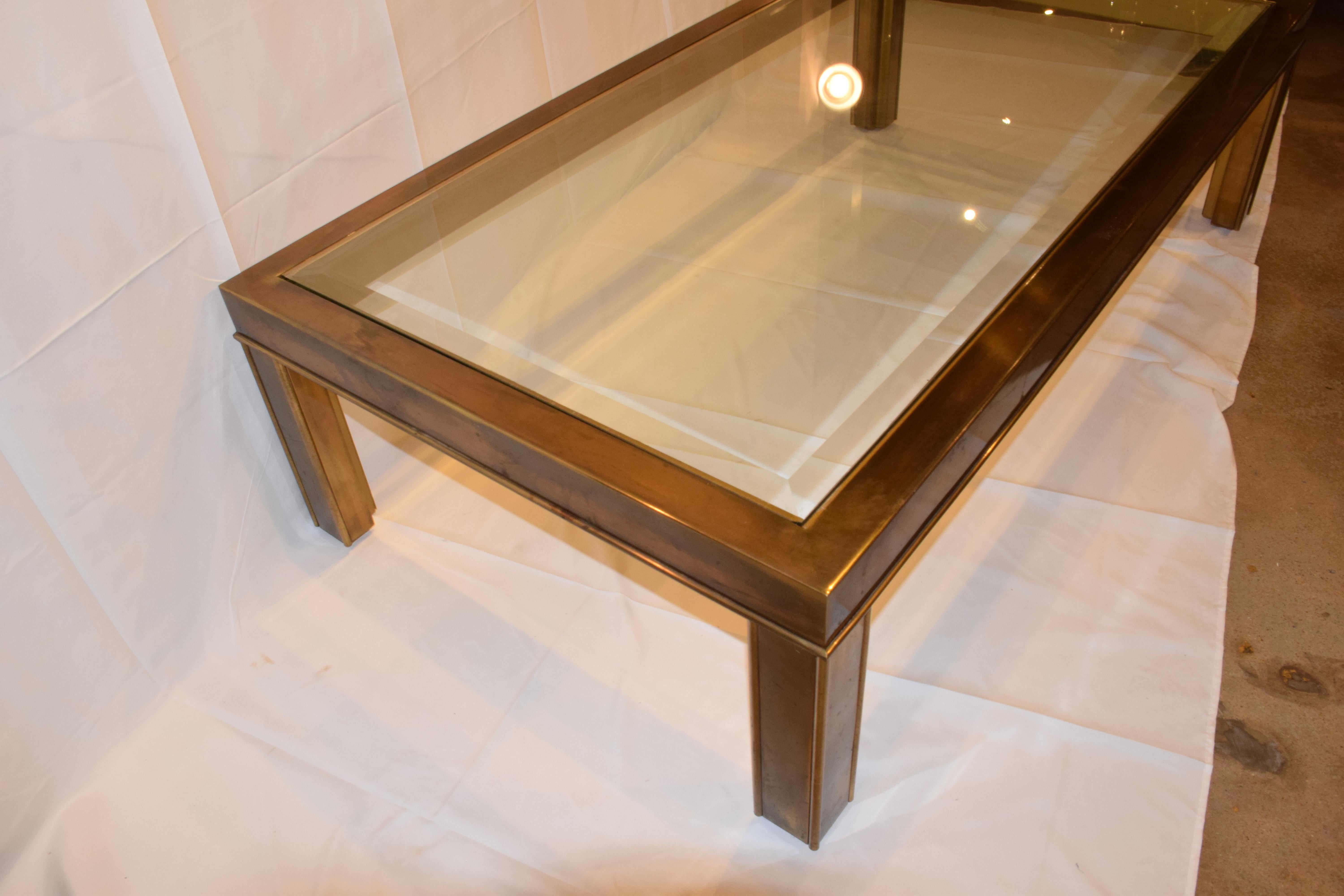 This is a rectangular brass cocktail or coffee table with original beveled glass inset top, by Mastercraft. The brass has aged with a lovely patina, and the piece is in very good vintage condition. This is a beautiful piece to add Mid-Century Modern