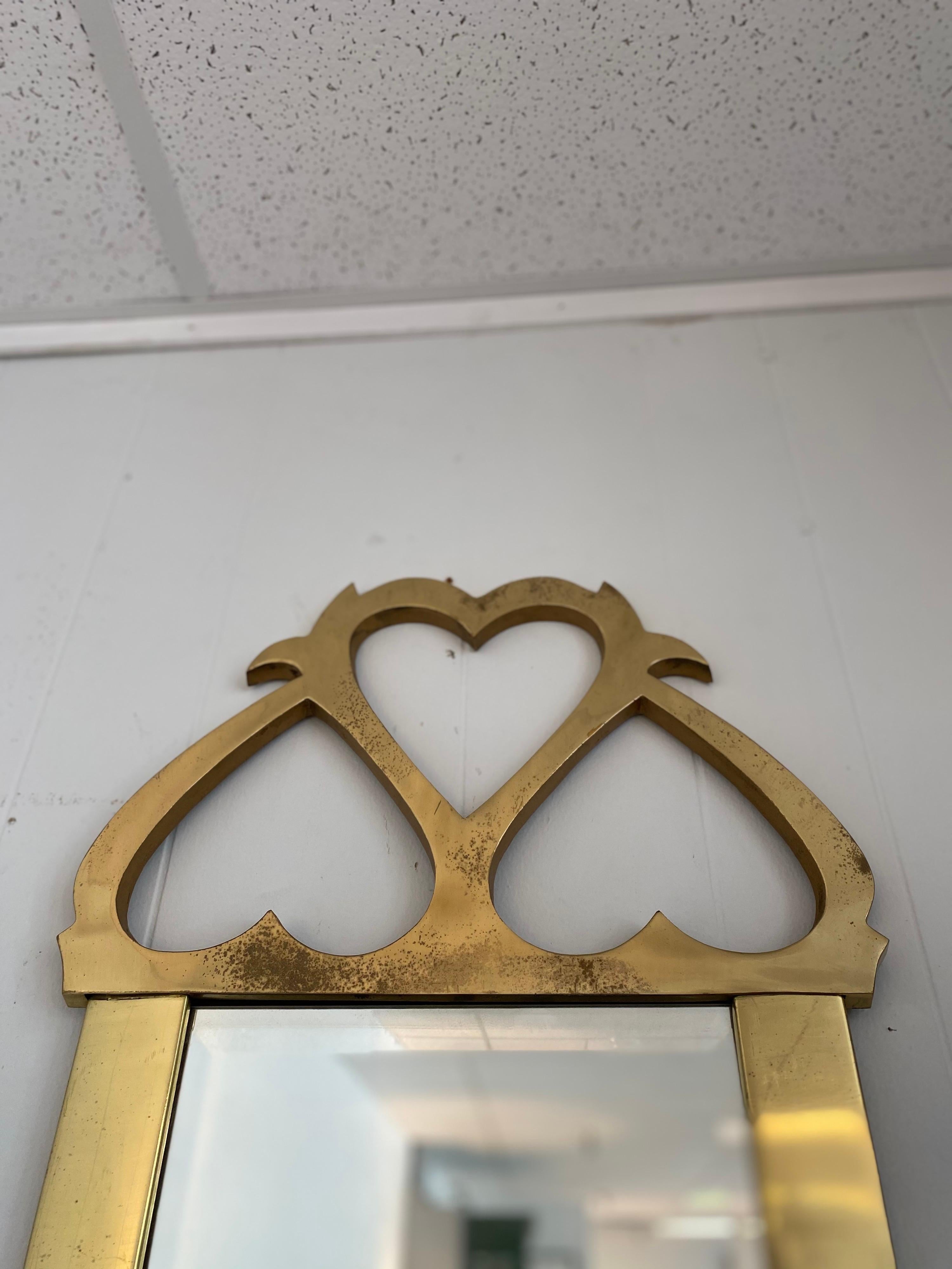 Vintage brass hanging mirror for Mastercraft has some patina but is in overall good condition. 
Width shown below is the measurement for the widest point at the bottom of the mirror. The mid-area of the mirror measures 14.50 inches.