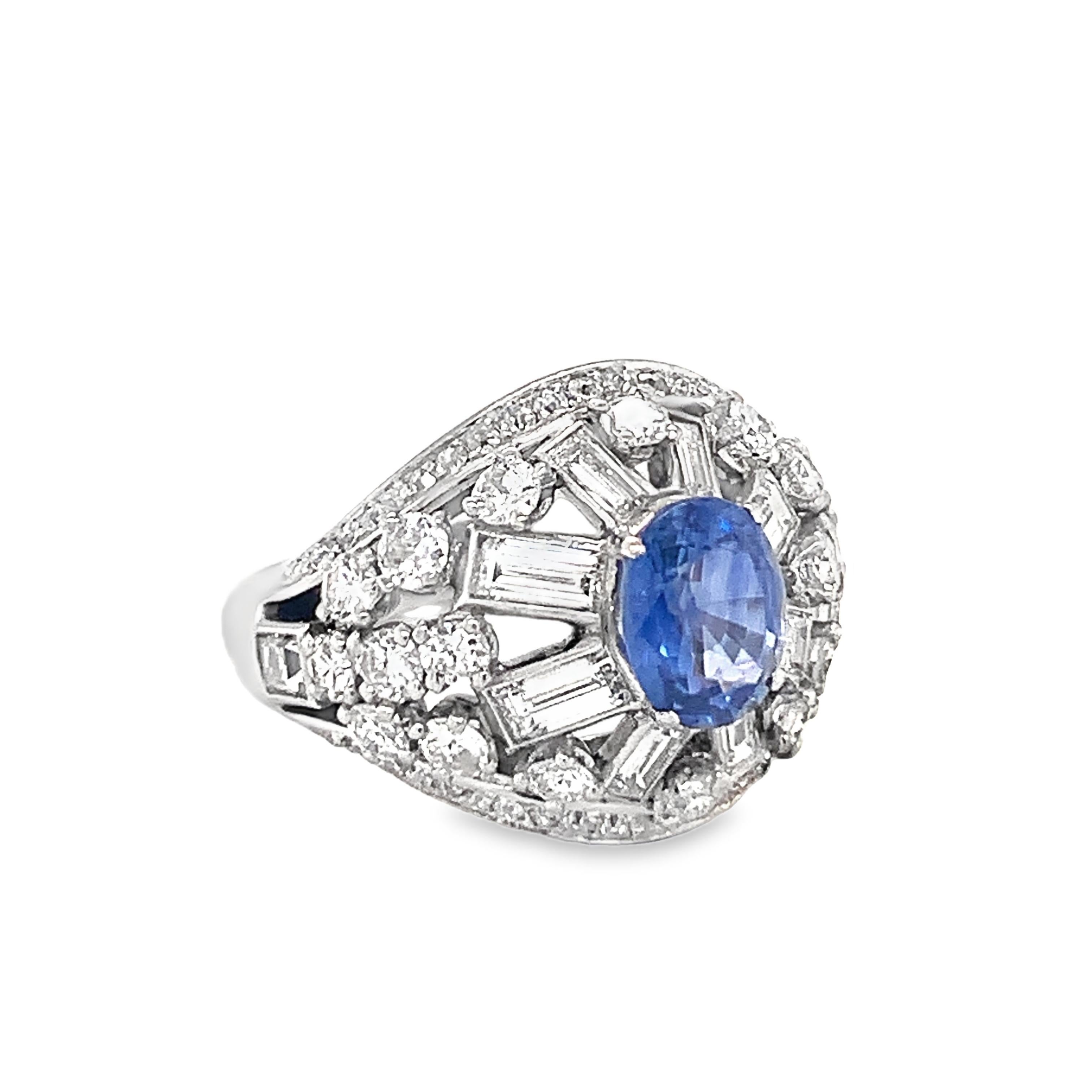 This unrivaled mid-century Mauboussin dome ring from the 1950s is a glowing testament to exquisite French craftsmanship. Set in luxurious platinum, the ring centers on a vibrant 2-carat oval brilliant-cut sapphire that radiates deep, rich color.