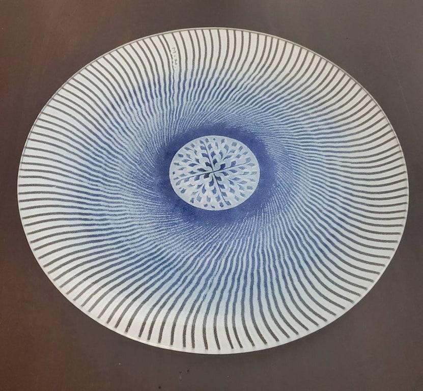Assiette de présentation en verre fusionné émaillé de Maurice Heaton (1900-1990) avec un motif de vortex émaillé en forme de soleil cosmique dans une couleur bleue riche et rare et un médaillon central. Signé M.H. au verso. Cela fait un beau centre