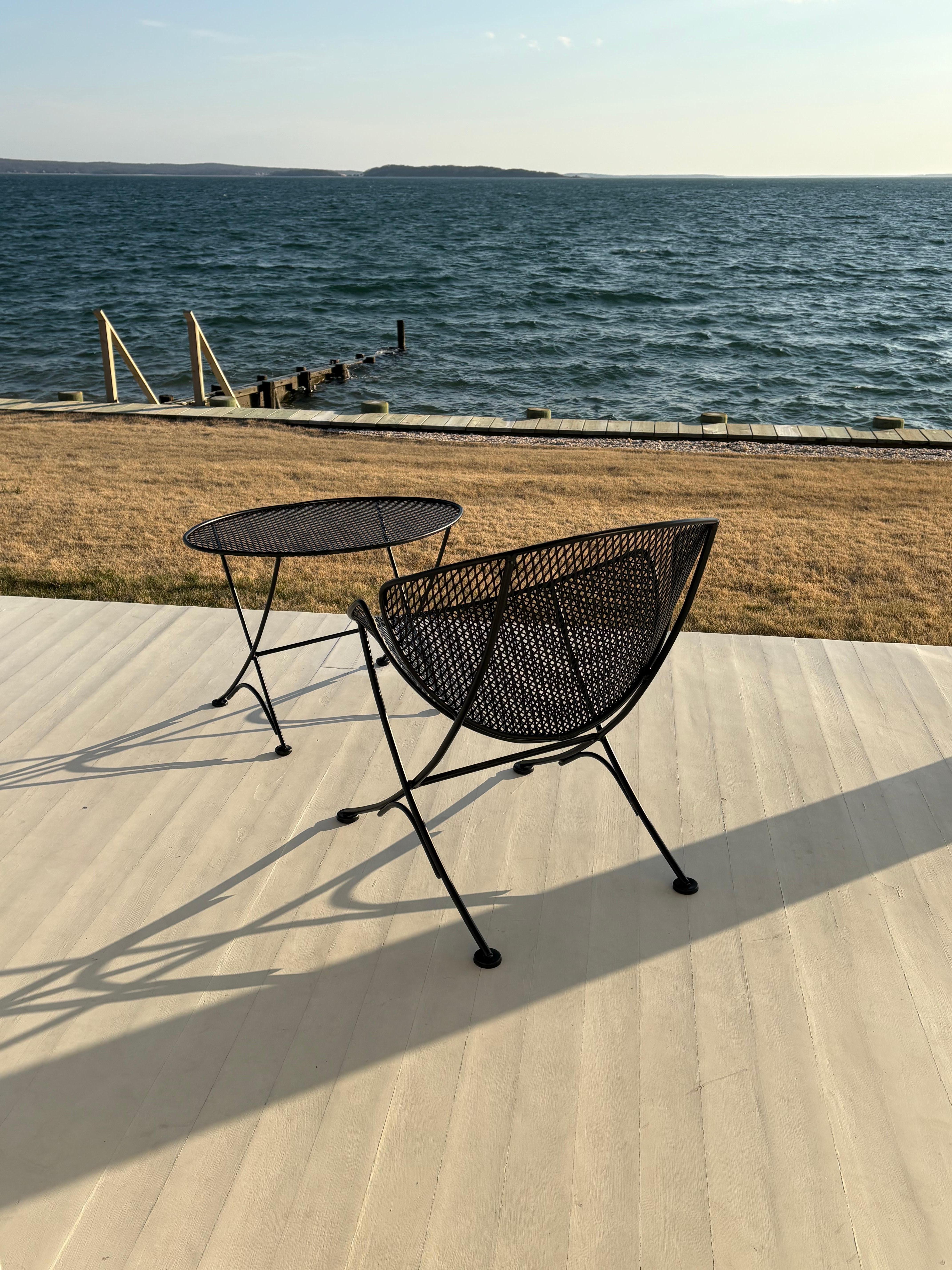Beautiful chair and side table by Maurizio Tempestini for Salterini called the “clam shell “ or “orange slice”. This coveted wrought iron chic design can be for outdoor or indoor use. The chair and side table are metal mesh over iron rod legs and