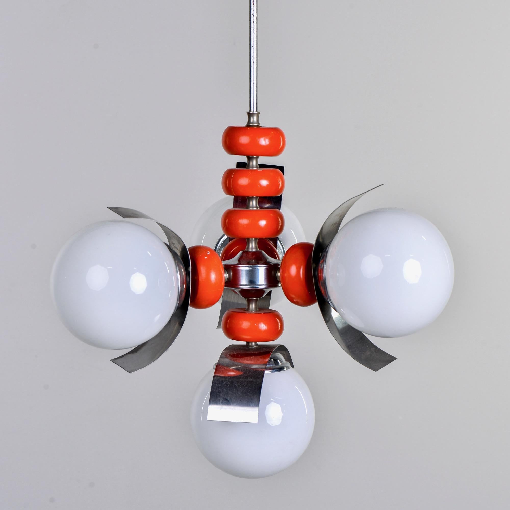 Circa 1960s four light pendant fixture attributed to Mazzega. Chrome canopy and rod with four white glass globes, orange-red wooden beads and chrome accents. New wiring for US electrical standards.

New wiring for US standards.

Some scattered