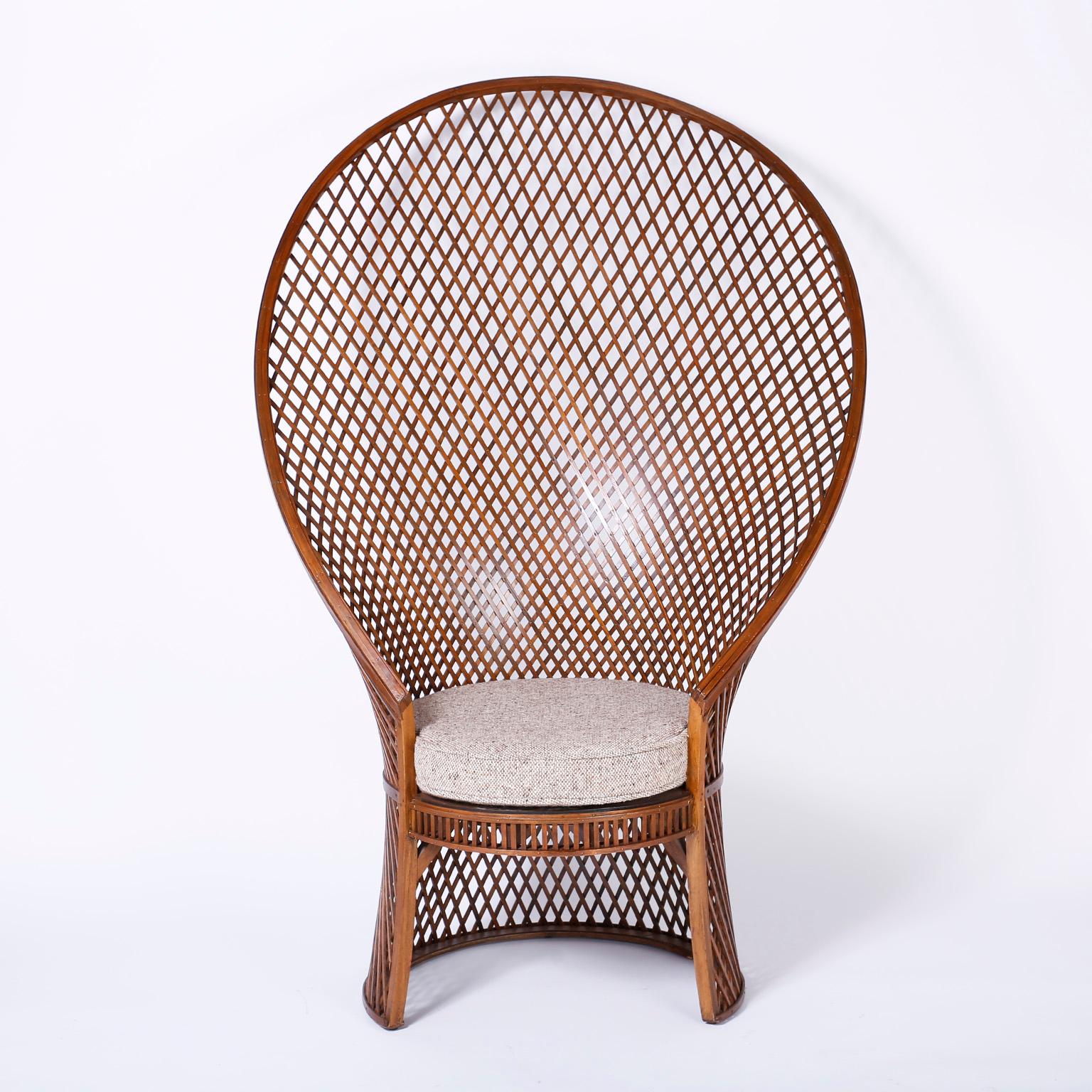 Rare vintage refined peacock chair, wicker or rattan at first glance, but actually crafted in walnut with an elegant and ambitious pattern of wood strips held together with brass brads. Signed McGuire on the bottom.