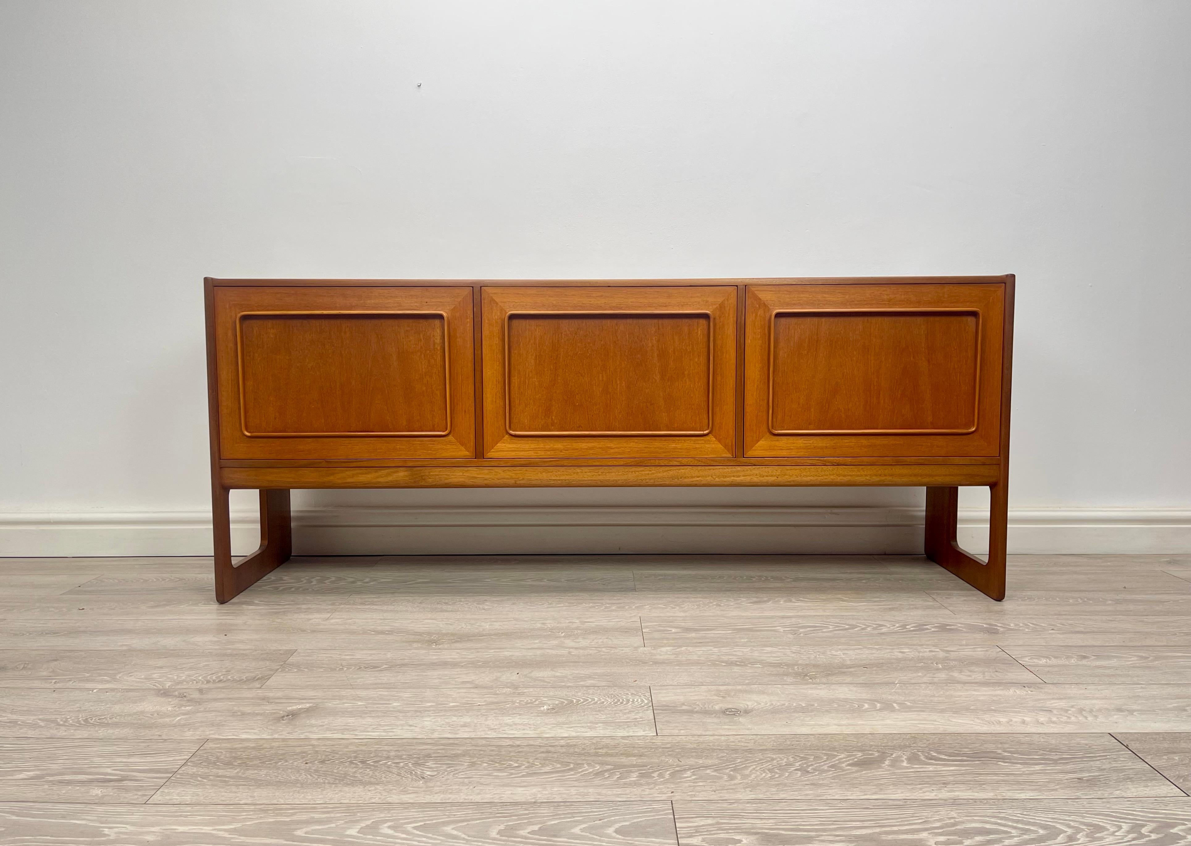SIDEBOARD 
Stunning midcentury teak sideboard made by Mcintosh cir 1960s . The sideboard has stunning grain throughout , there’s three single cupboard , two cupboard have fixed shelves , centre cupboard has drop down door .

Height - 70 cm 
Depth -