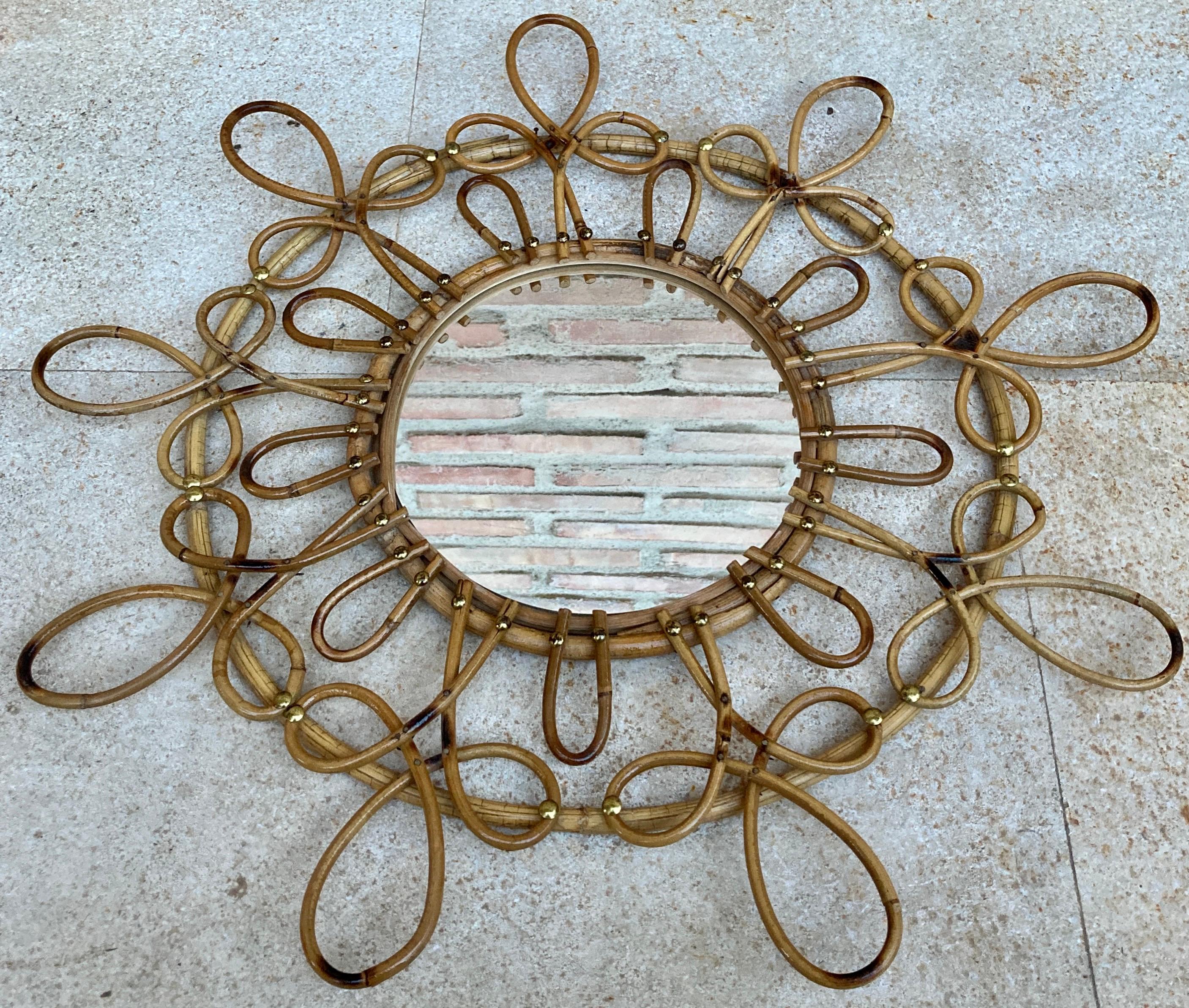 Double layered rattan sunburst flower shaped mirror. France, 1960s. 
A lovely Mediterranean style handcrafted rattan flower shaped mirror with two layers of petals in two sizes and pyrography accents. 
Beautiful to place alone and interesting as a
