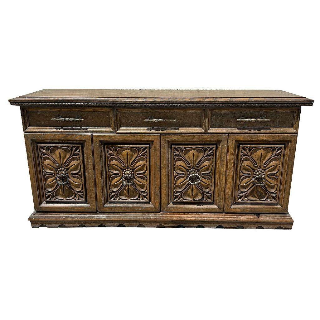 Buffet per sala da pranzo in stile Revival mediterraneo della metà del secolo scorso, con frontali di cassetti e armadietti squisitamente intagliati. La sua struttura elevata è caratterizzata da cassetti in ottone e ante dell'armadio a due ante con
