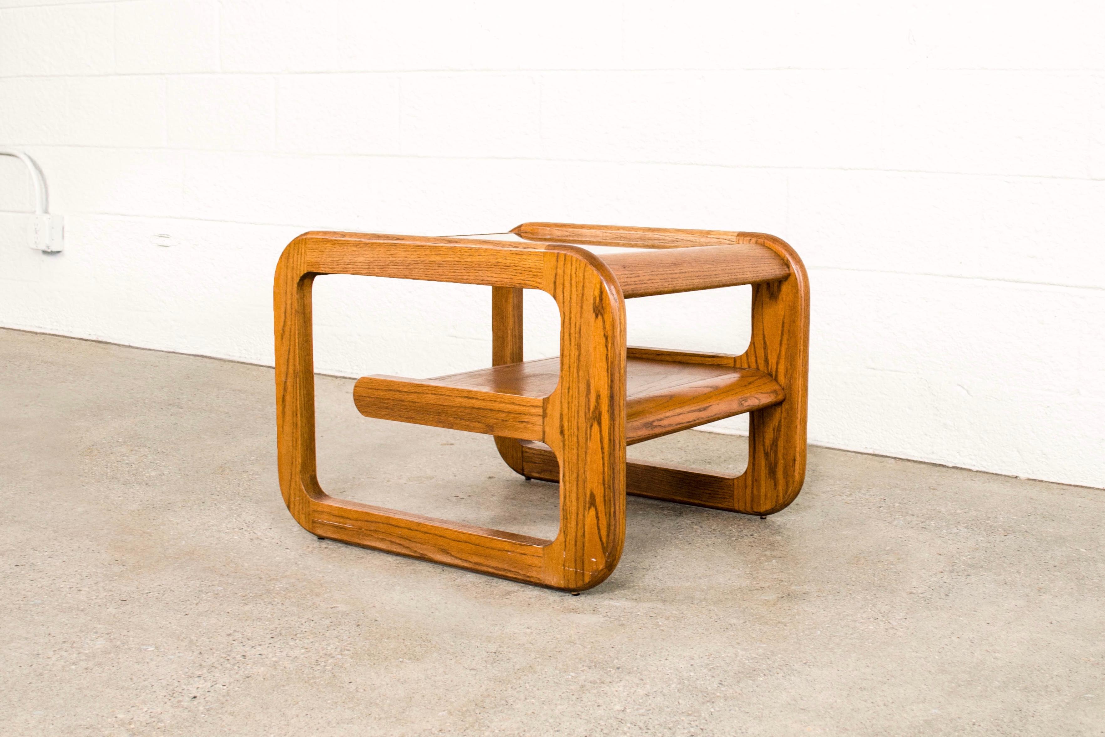 This vintage Mid-Century Modern Mersman Bellaire coffee table has fabulous 1970s style. The table features a solid oak frame with rounded edges, a cantilevered lower shelf and a tinted and beveled glass tabletop.

Dimensions:
W 23