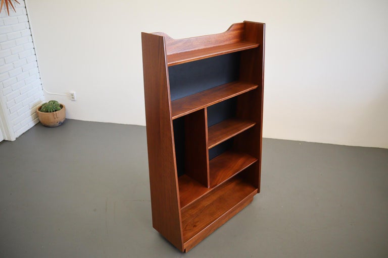 An impressive example of Mid-Century Modern craftsmanship. This impeccably well designed bookcase by Merton Gershon for Dillingham. Multiple levels of display allow for object, art and literture. Solid walnut build with black satin lacquered wood