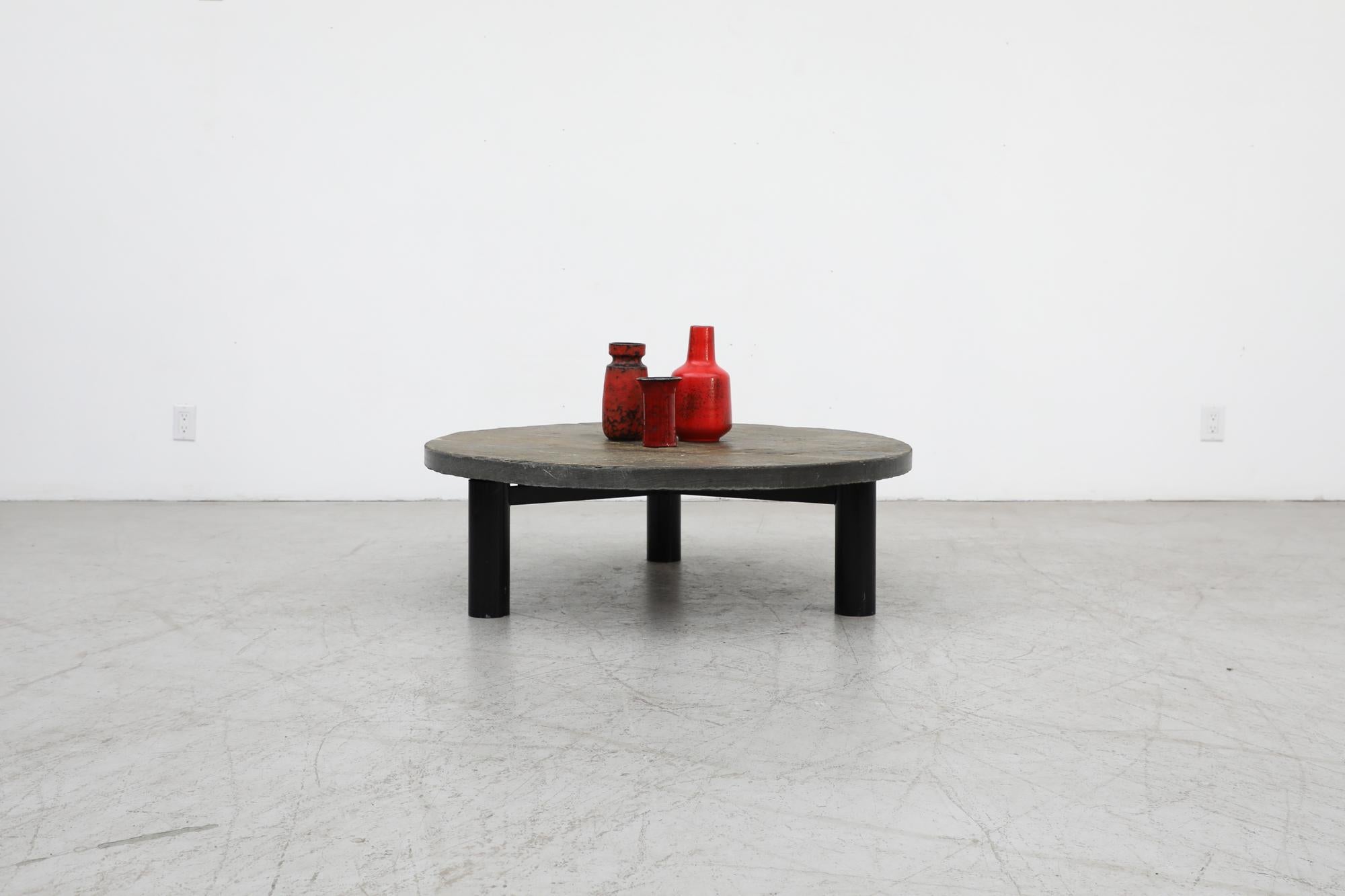Brutalist 1970's Metaform (attr) stone coffee table with an extremely heavy, thick solid stone top and fat black enameled tripod base. Stone top has shades of grey and brown and is 1.625” thick. In original condition with visible wear including