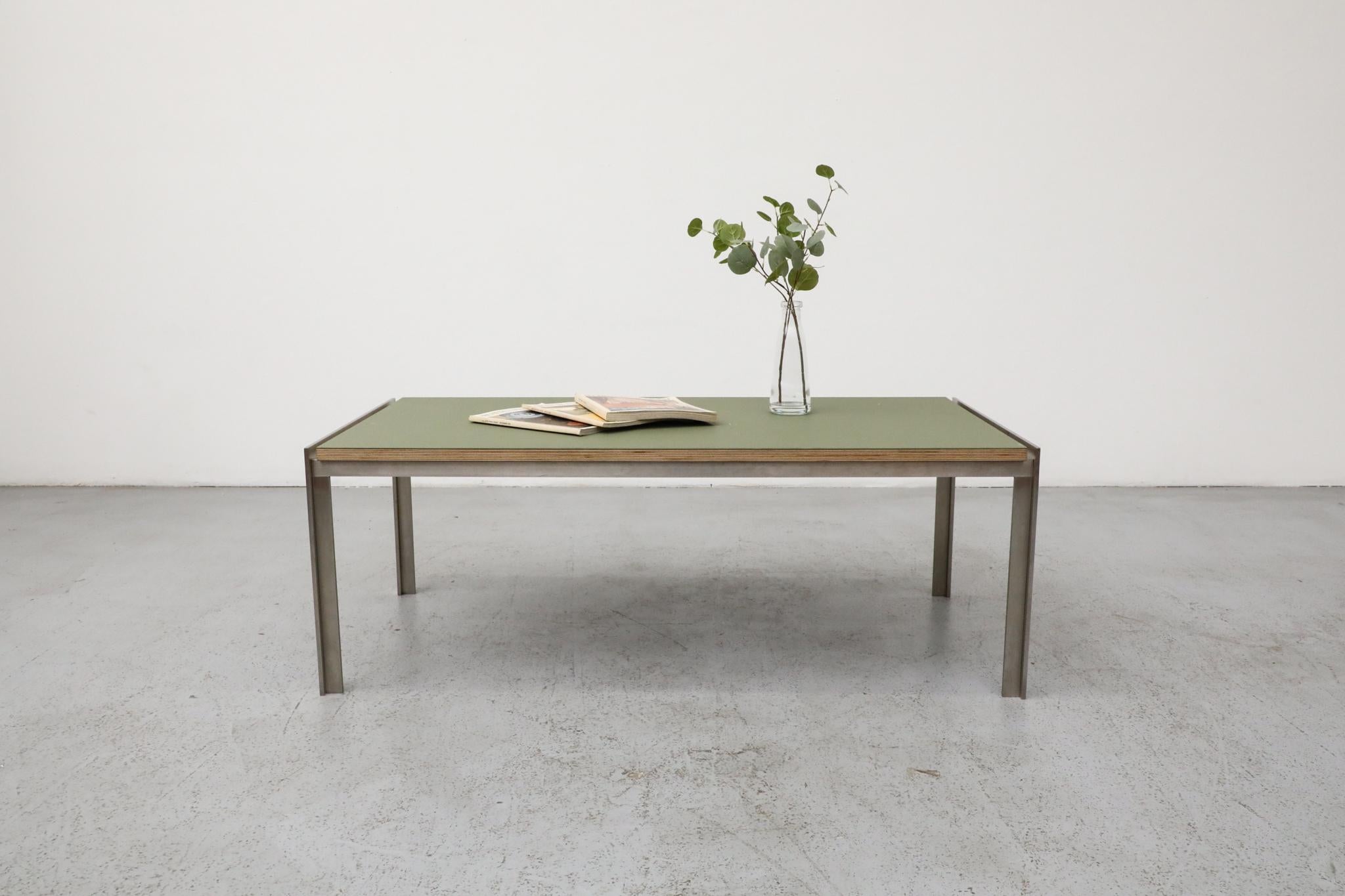 Sleek Mid-Century coffee table by Dutch manufacturer Metaform features a modernist brushed steel frame with green laminate top over marine plywood. The clean lines and minimalist form are hallmarks of Metaform’s refined design approach, which gained