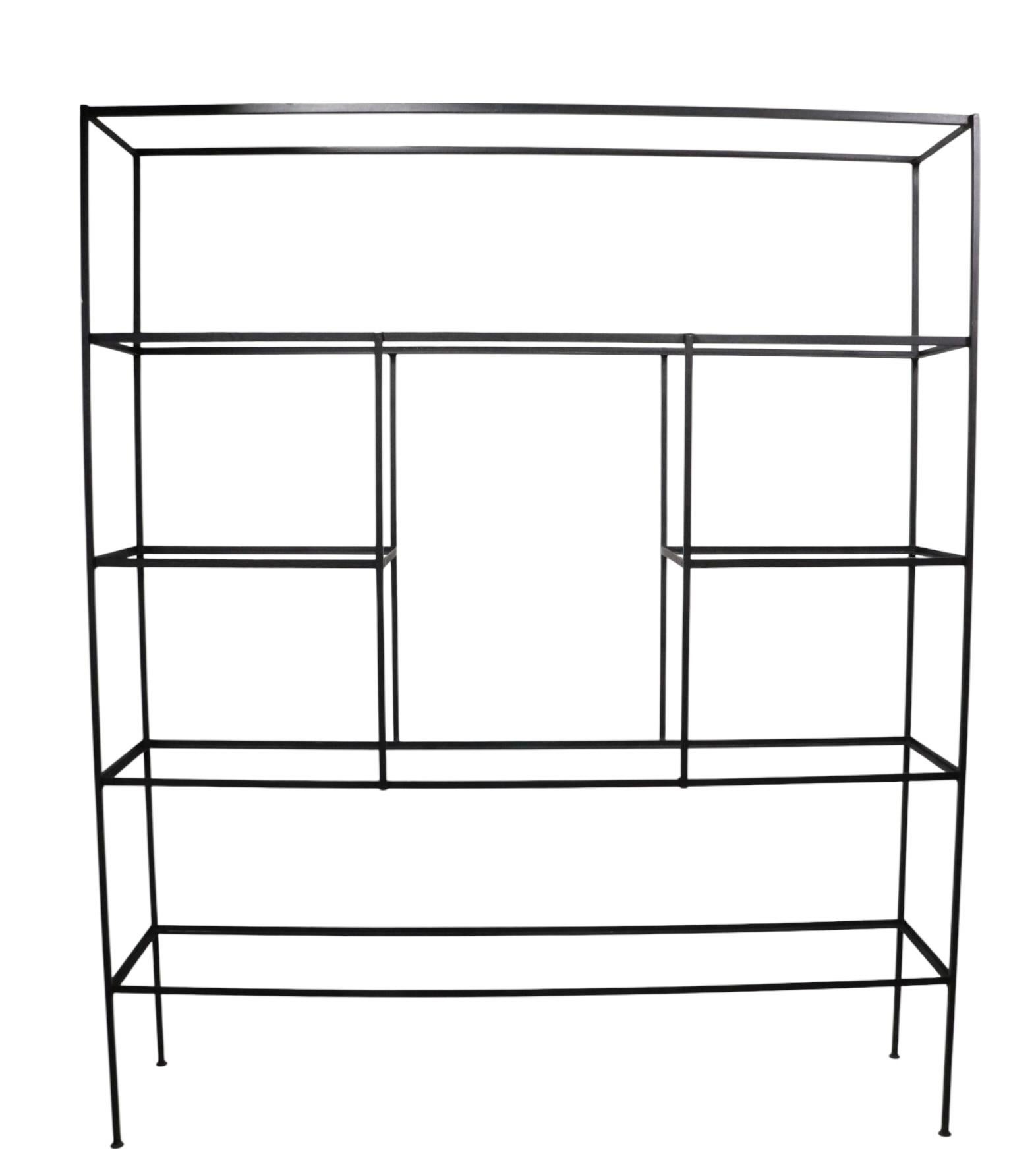 Architectural Mid Century metal and glass freestanding  shelf unit, having six drop in glass shelves, mounted in a solid squared stock iron frame.
 The shelf is in very good, clean, ready to use condition, the glass shelves show minor surfaces