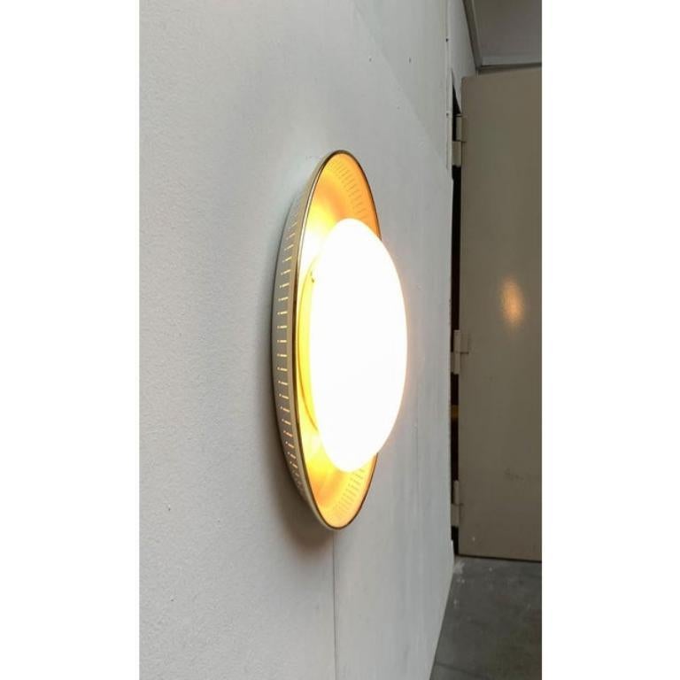Imposing Mid-Century ceiling or wall light.

The lamp consists of two parts. The arched reflector tub and the glass front element. The glass diffuser ensures a diffuse light distribution and protects against glare through the lamps. The escaping