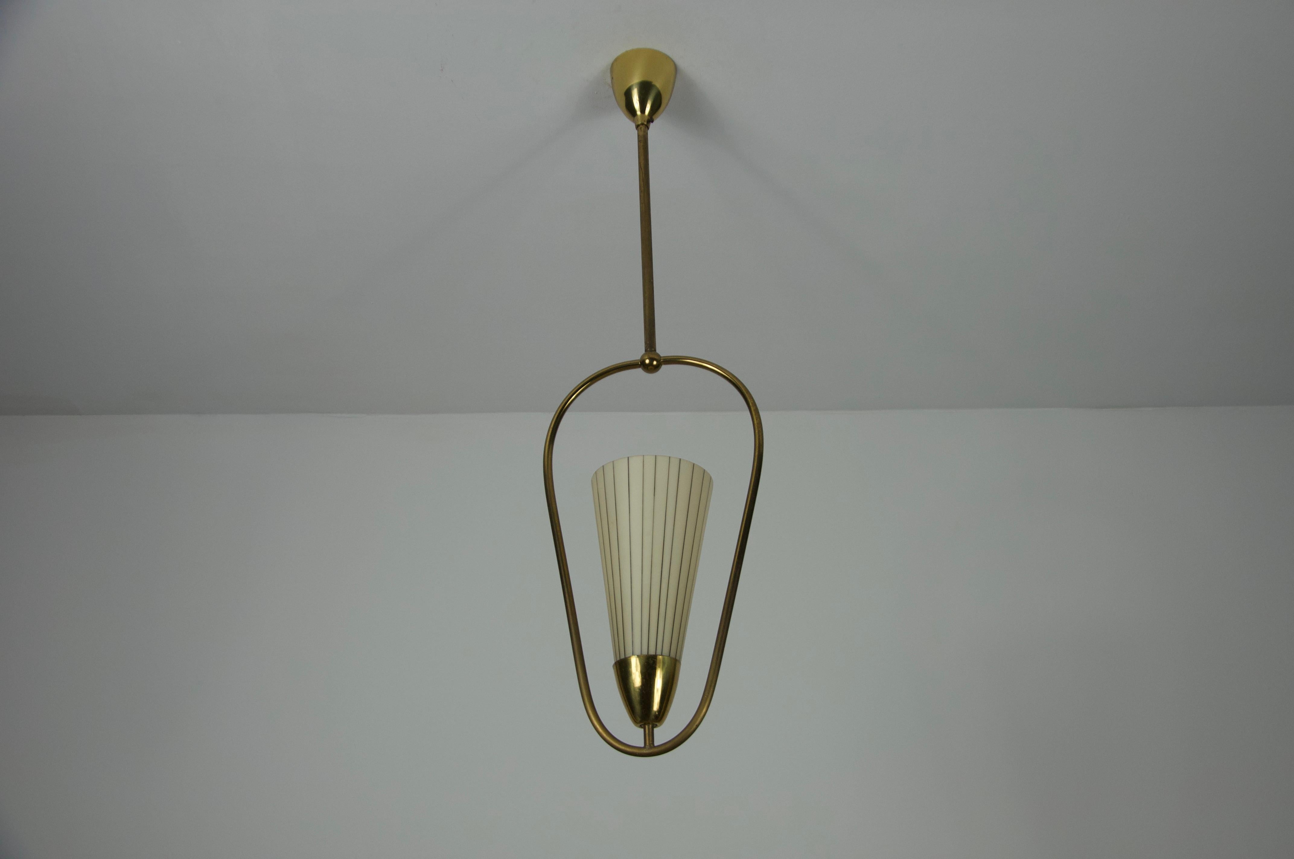 This elegant ceiling lamp from 1960s Germany showcases a refined combination of brass and opal glass. The opal glass diffuser is seamlessly integrated into the brass frame, creating a sophisticated and balanced design.

With its timeless aesthetic