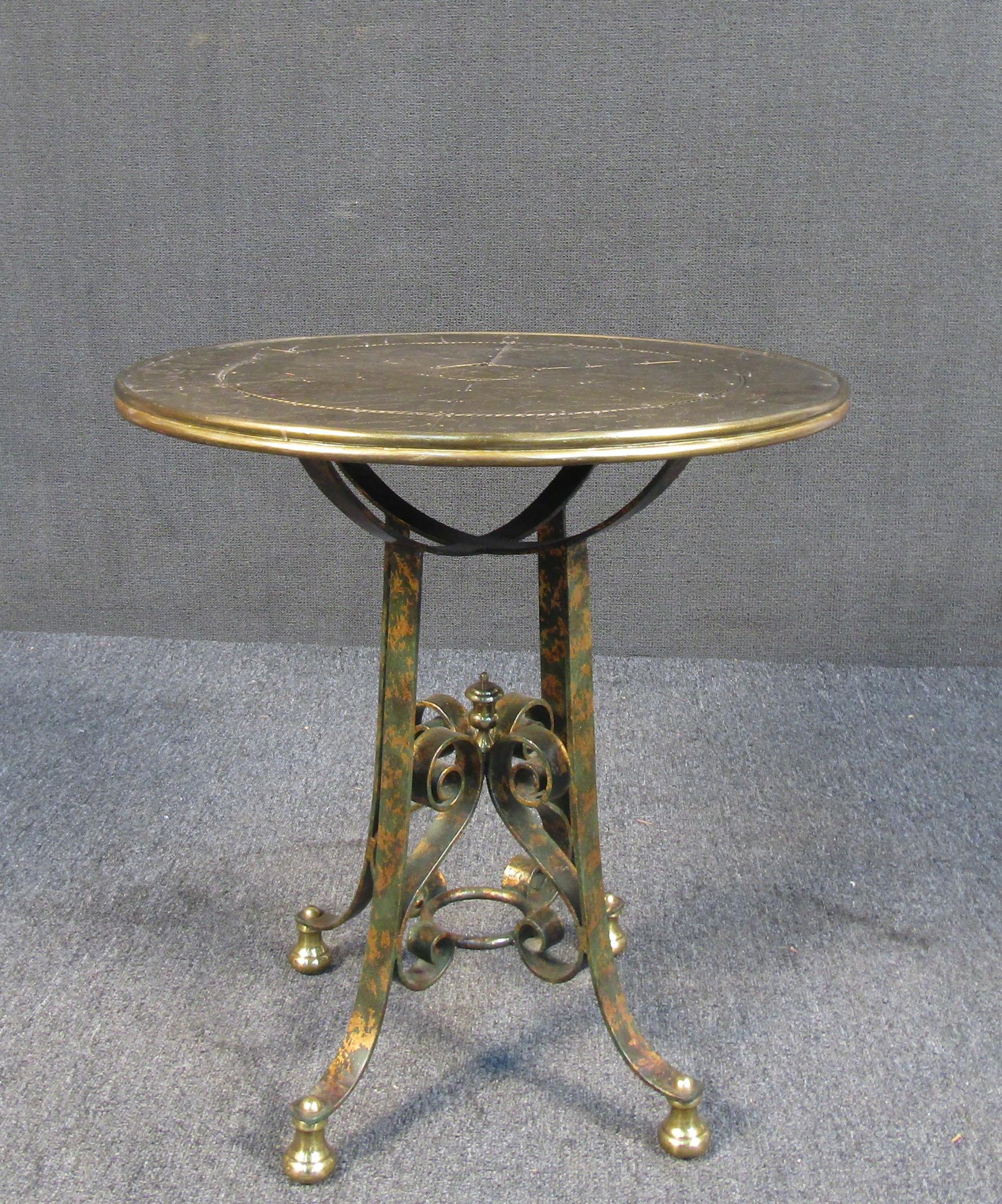 Cette table unique en métal présente un plateau d'inspiration asiatique, ainsi que des accents métalliques roulés et ornés. La finition dorée donne à cette pièce un aspect sophistiqué, parfait pour toute maison ou bureau de style