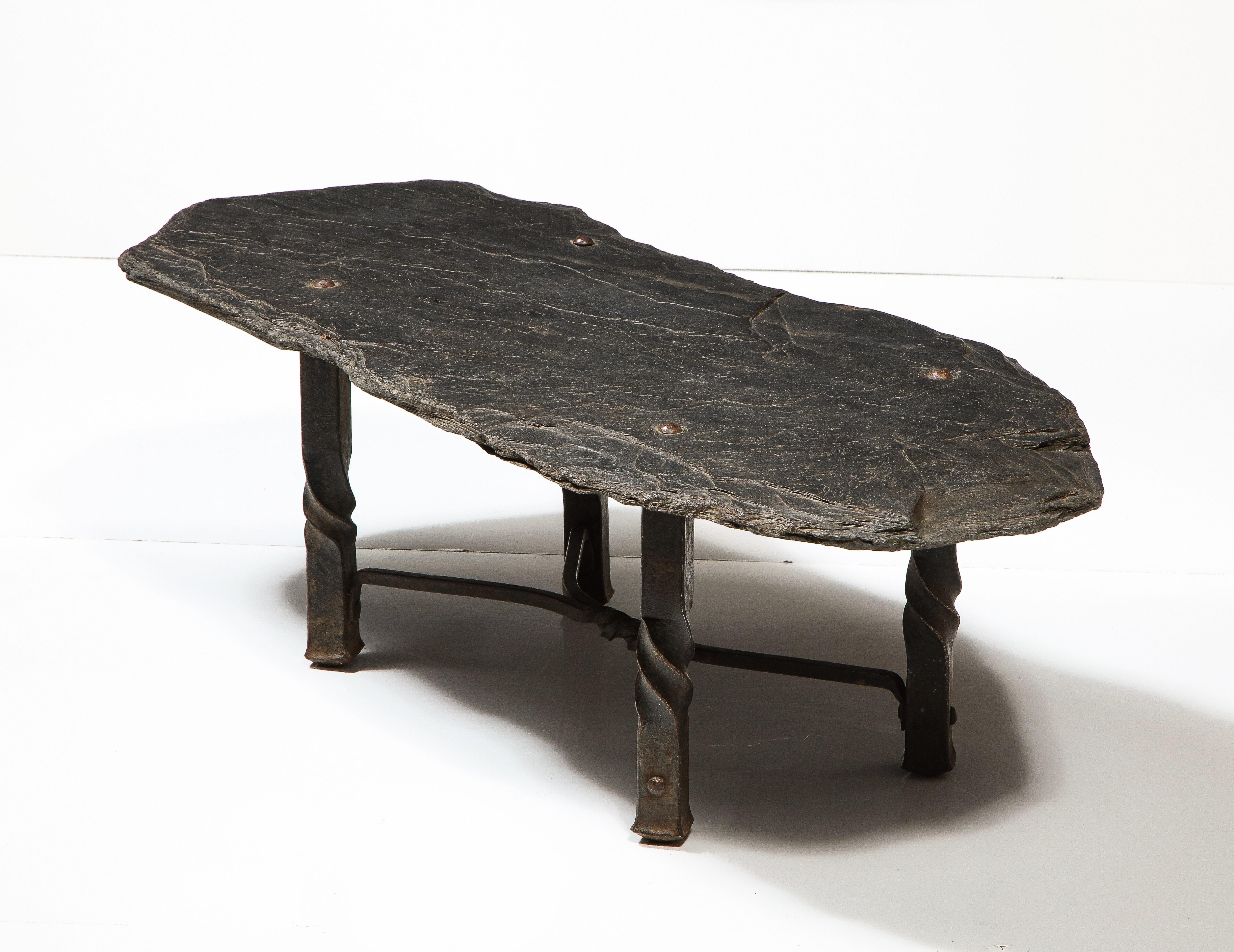Mid-Century Metal Coffee Table with Stone Top, France, c. 1960s. 

This exceptional coffee table consists of a cast base with exquisite metalwork as well as an irregularly shaped stone top with gorgeous character and patina. The table is in