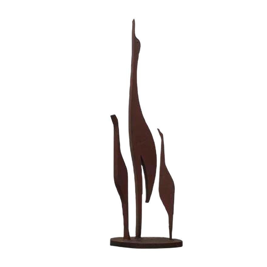 Elegant bird sculpture made of solid steel.

This monumental sculpture depicts three abstract birds of different sizes, standing watch in a group up. The way reminiscent of Mid-Century crane- or herons wall figures in teak.
Remarkable are fine