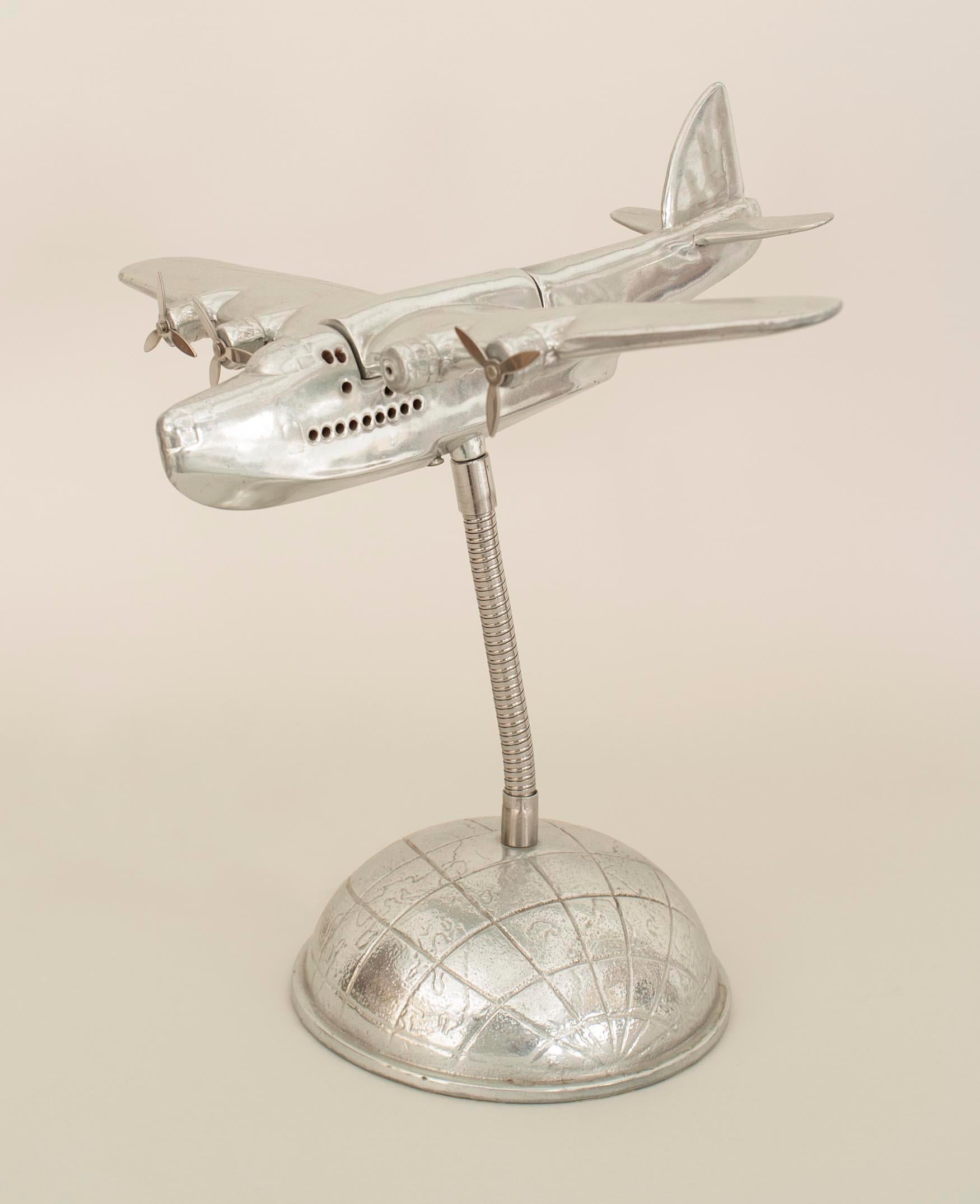 American Mid-Century metal model airplane with propellers mounted on a Â½ globe base (with a light inside the plane)

Missing one propeller