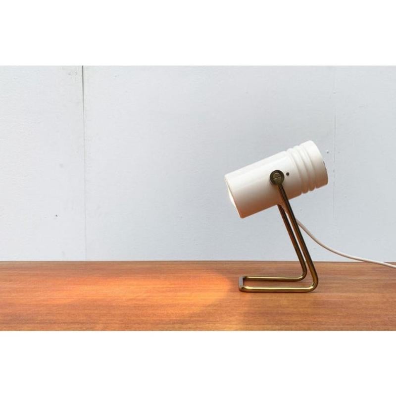 Petite lampe de table Mid Century.

La tête cylindrique de la lampe est ouverte d'un côté et mobile. Cela lui permet de s'incliner de haut en bas. La base est dissoute dans un support. L'aspect général de cette petite lampe évoque des associations à