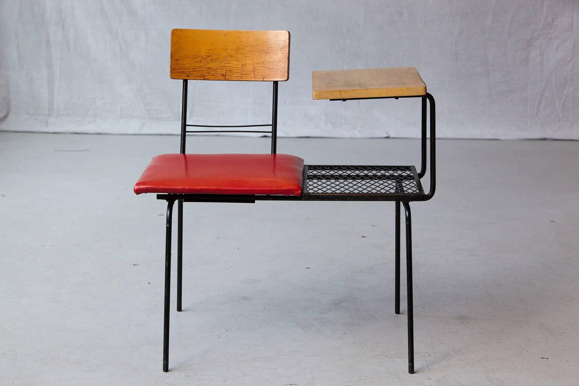 Midcentury black metal wire telephone table with integrated bench or seat covered in red Naugahyde. The seat and back unit can be positioned in a 180 degree direction to fit for left or right hand people.
Measures: Seat height 16.5 inches.