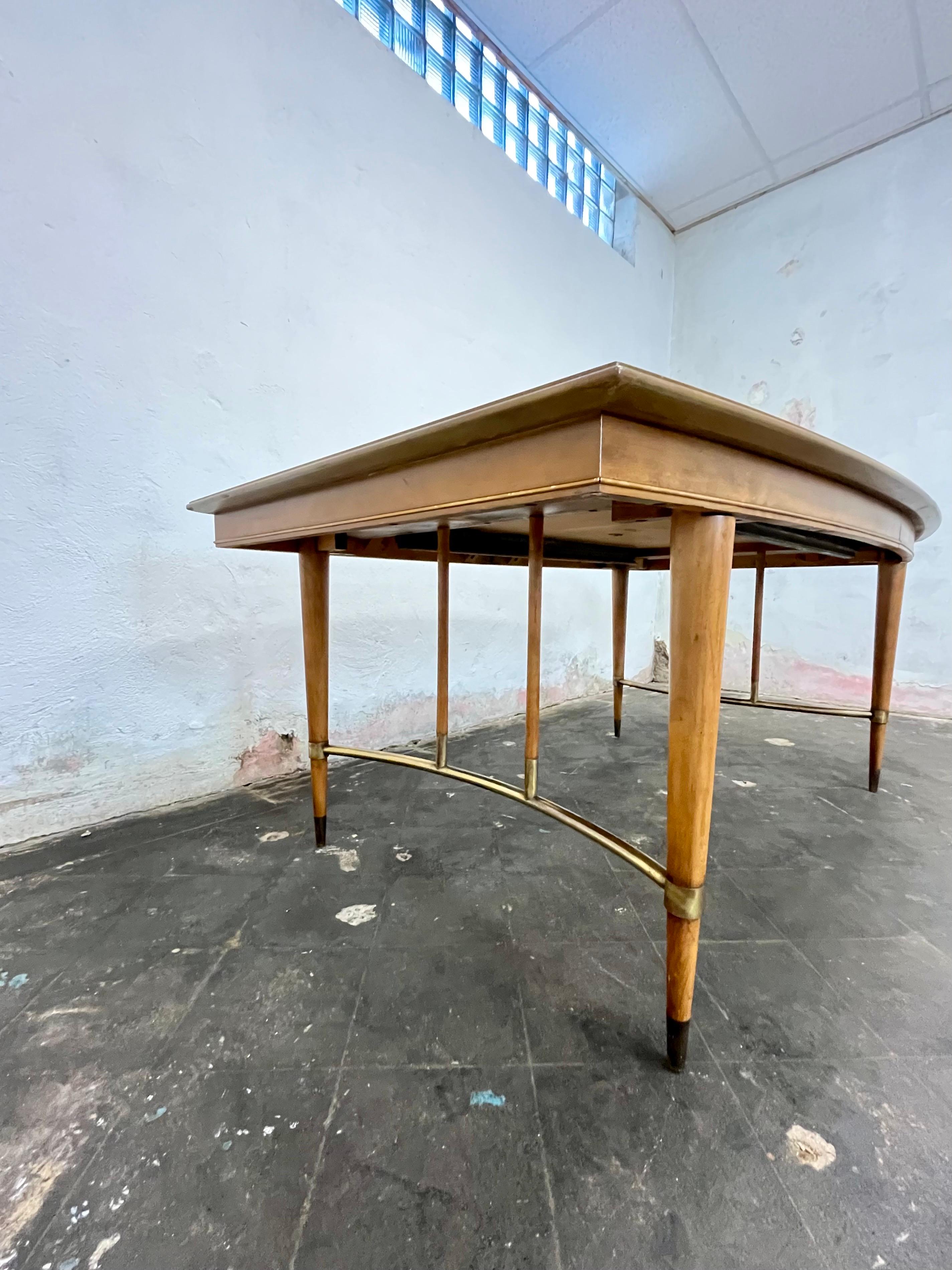 Handsome and sophisticated  mid century dining table by Metz. Great boat shape with matchbook veneer and spectacular brass accents. 2 added leaves open to a large table with room for 10-12. 
Fully extended 99.5