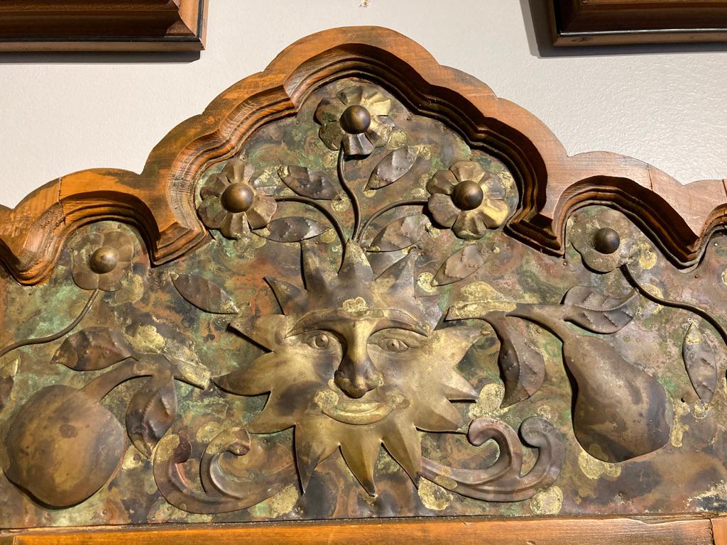 A wonderful hand carved with exuberant decorative motifs including a sunburst surrounded by apples, pears, flowers, bunches of grapes and other floral decorations. Beautiful patina varying from verdigris to deep copper with gilt highlights. This is