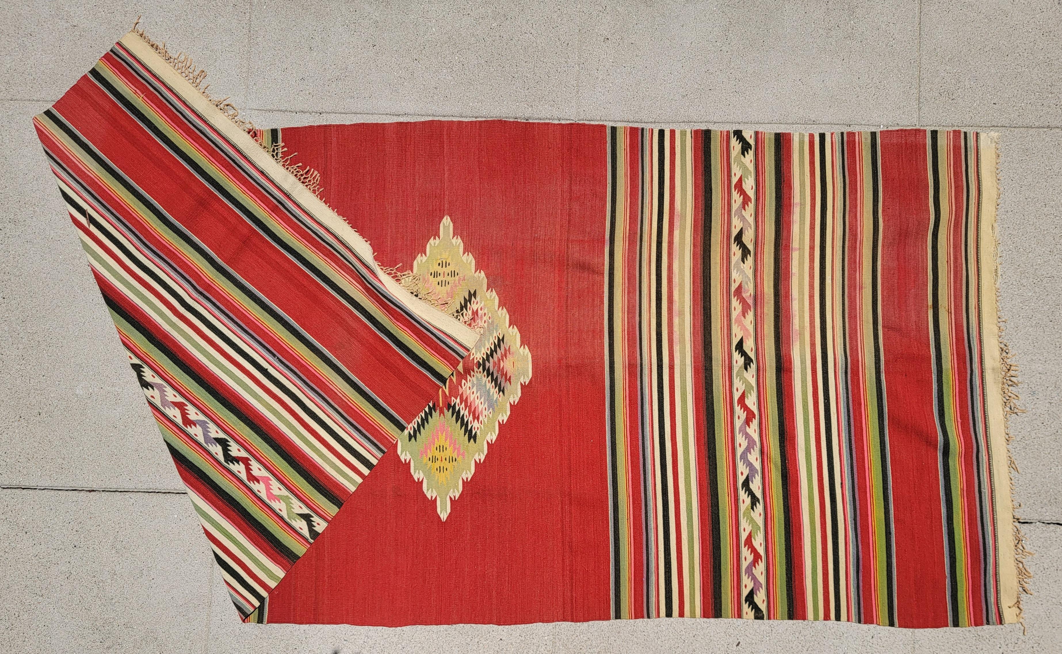 Beautiful Mexican Indian woven serape in a bright red background color. Yellows and greens bring the patterns to life. The weaving itself in hand made. There are slight browns, pinks and greens in the pattern that show life to this serape. 