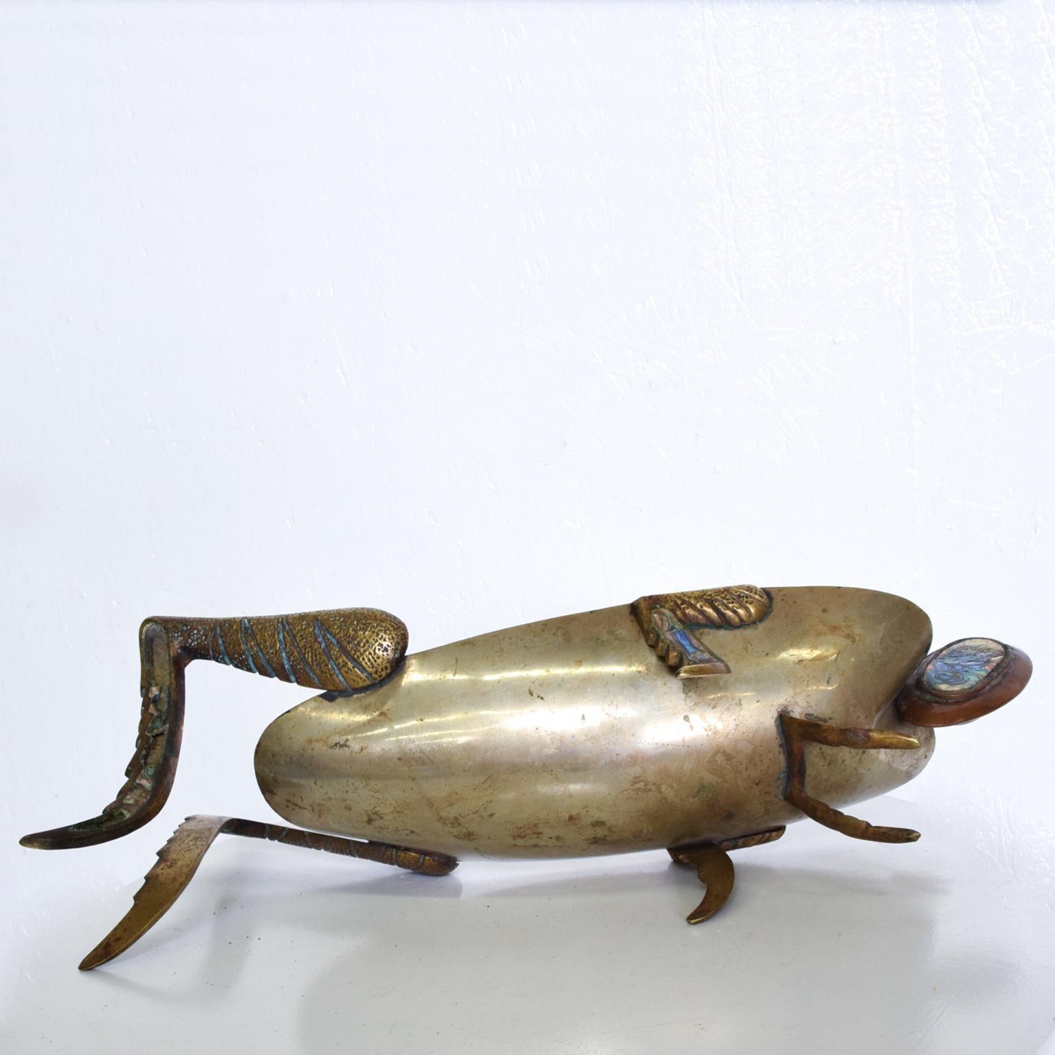 For your consideration, a decorative bowl with the shape of a grasshopper. Brass with the faded silverplated finish. Legs and eyes are decorated with abalone. Unmarked. Attributed/In the style of Los Castillo. Made in Mexico, Circa the 1970s.