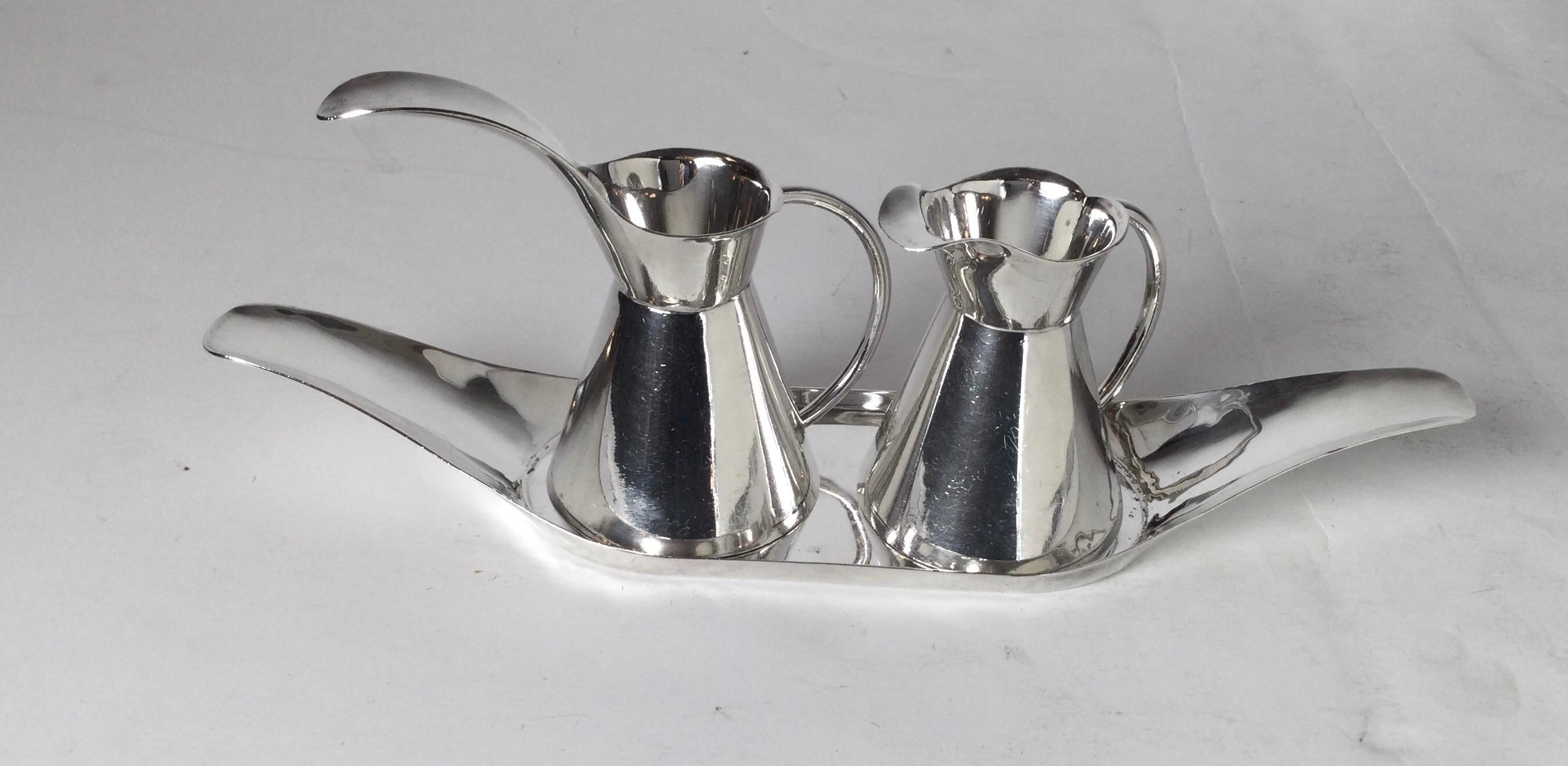 Midcentury Mexican sterling silver condiment set by Sanborn, two loop handled decanters residing on an elegant tray. The decanters are sculptural in form. Excellent condition
Dimensions: 3.75