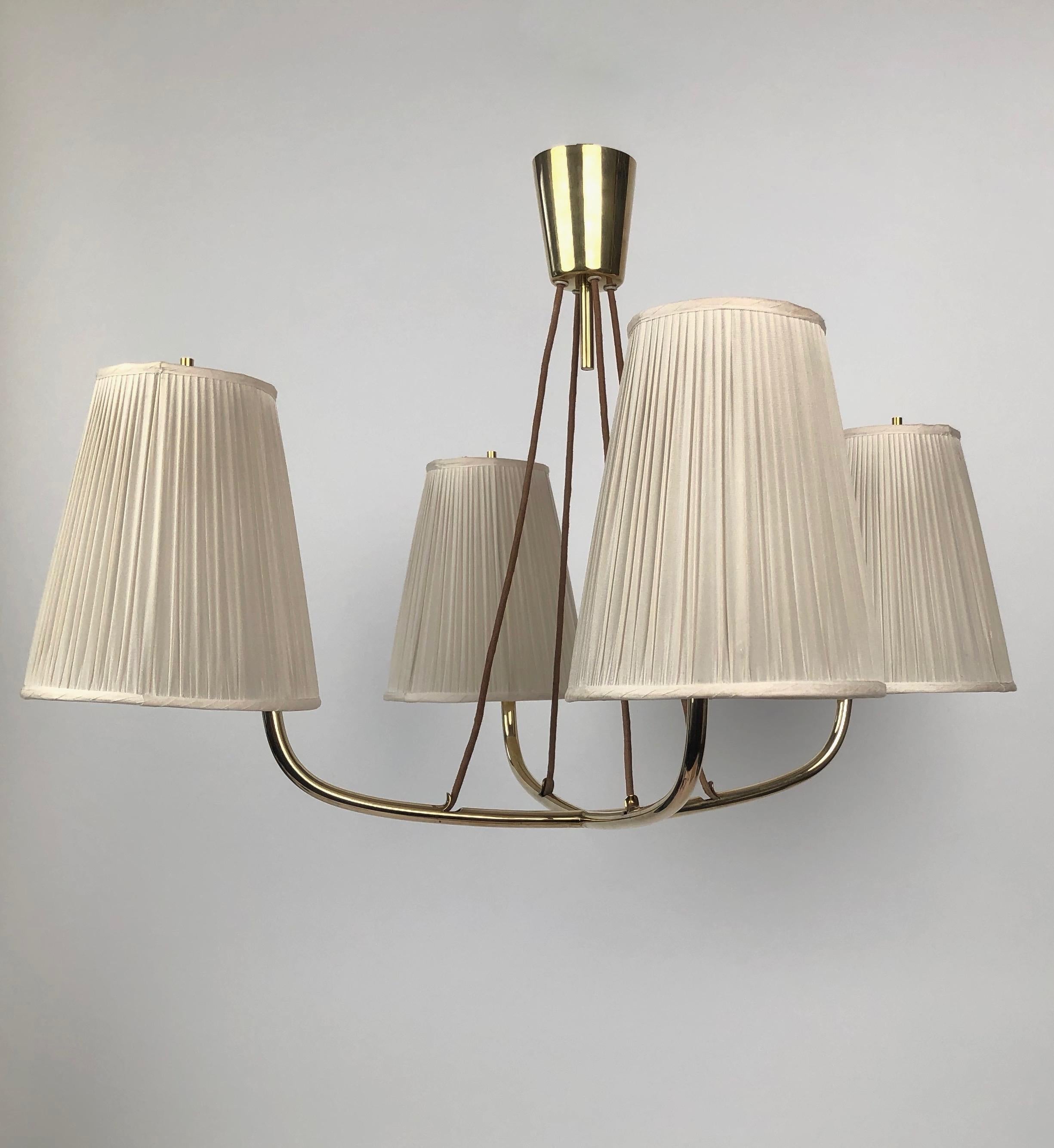 The Mexico Chandelier was designed by Jonathan Browning in the 1940's, it gently hangs from the ceiling on 4 cloth covered cords and emits a soft bright light that is elegant and functional . Made of polished brass, this example was manufactured in