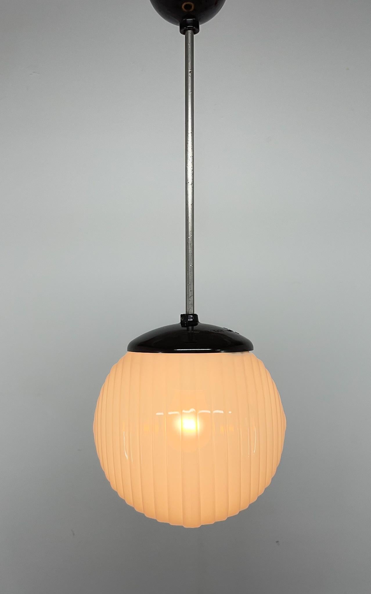 Vintage pendant light from the 1970s. Combination of bakelite and milk glass. Very good vintage condition.