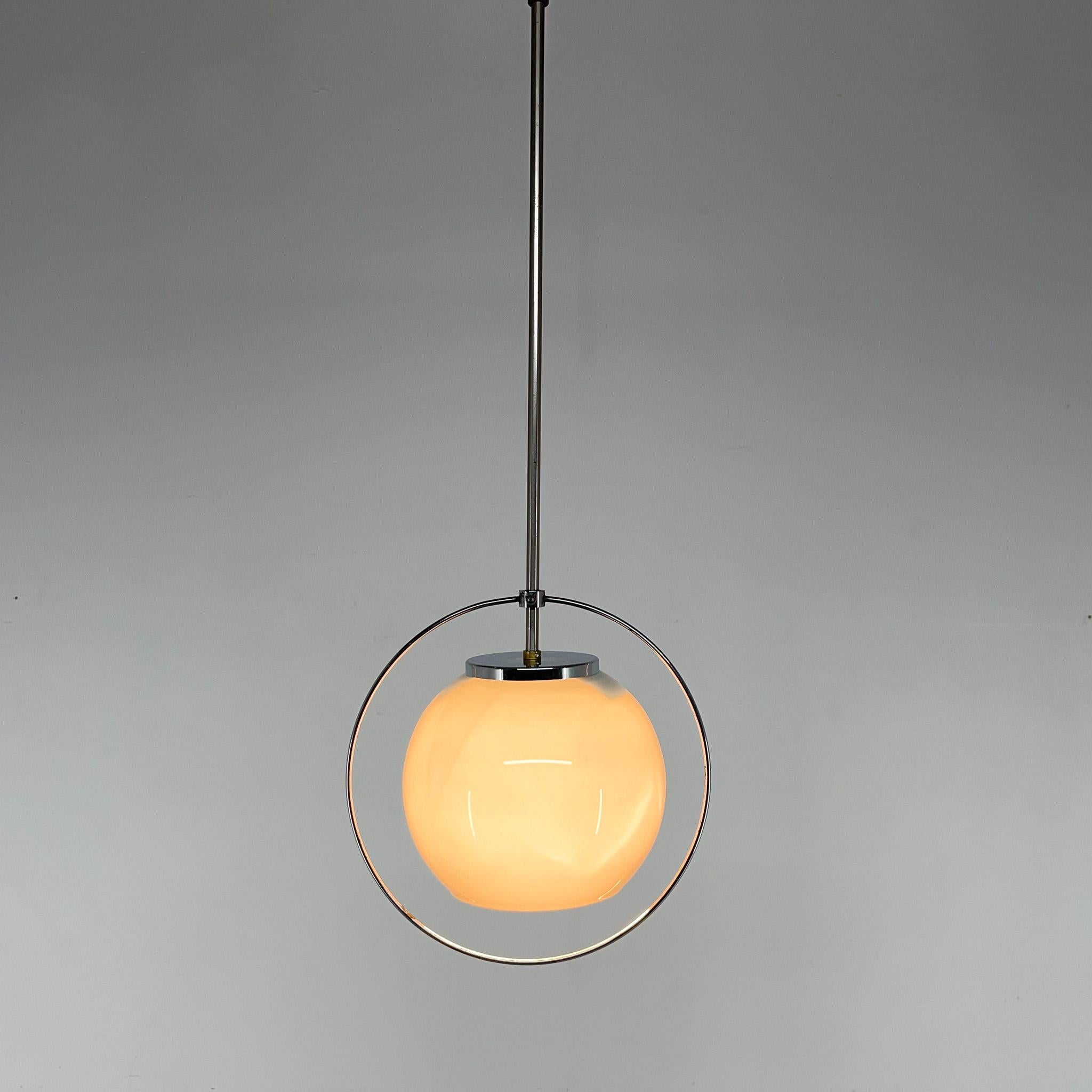 Bellissima lampada a sospensione cromata con sfera in vetro al latte e decorazione a cerchio cromata. Lampadina: 1 x E25-E27.