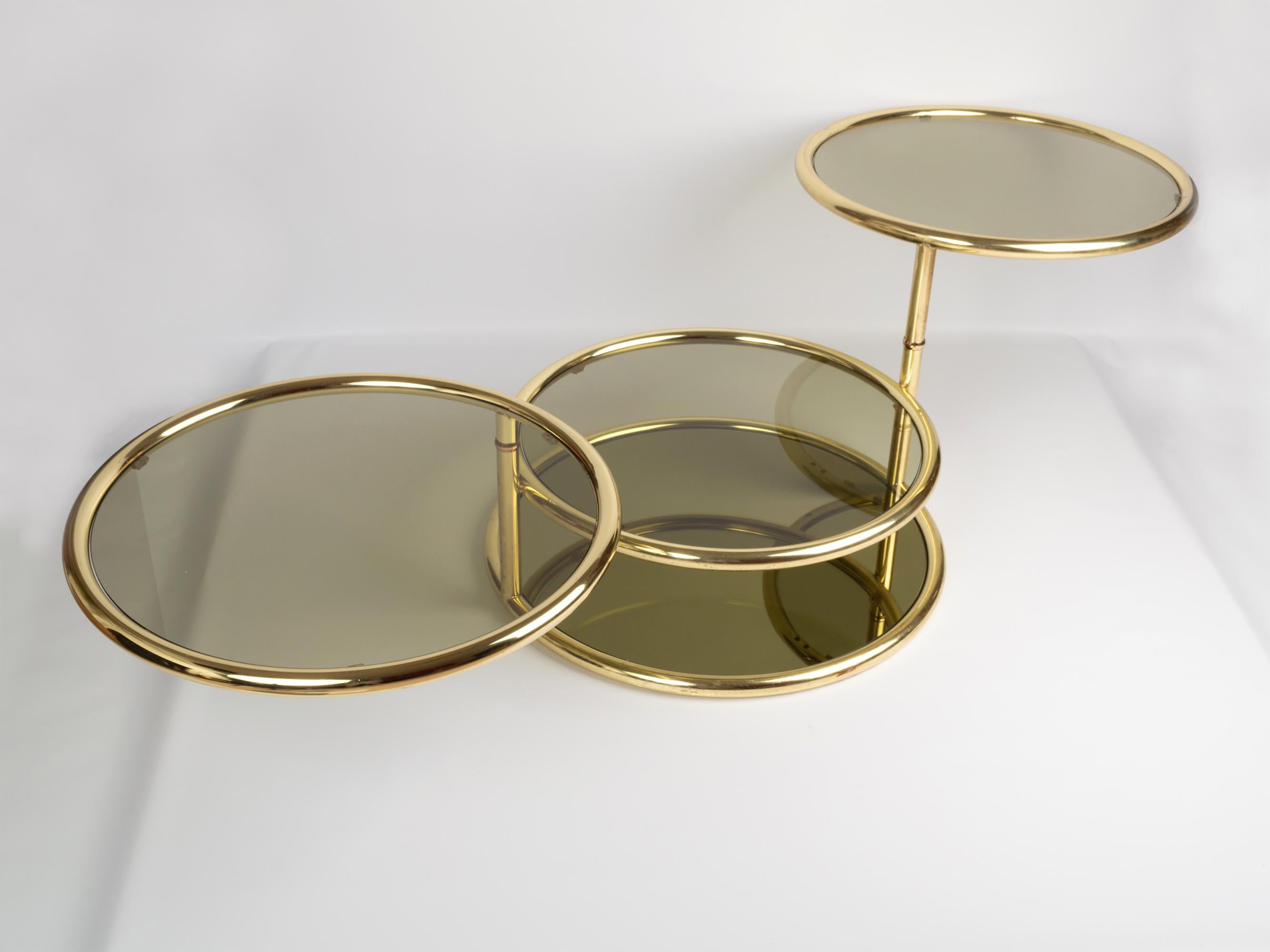 Midcentury circular brass swivel tiered coffee cocktail table, attributed to DIA, USA, circa 1970.
Polished brass and smoked glass.
Dimensions:
H 46 x D 70 x W 187cm fully expanded.
Wear consistent with age and use, expected areas of tarnish and