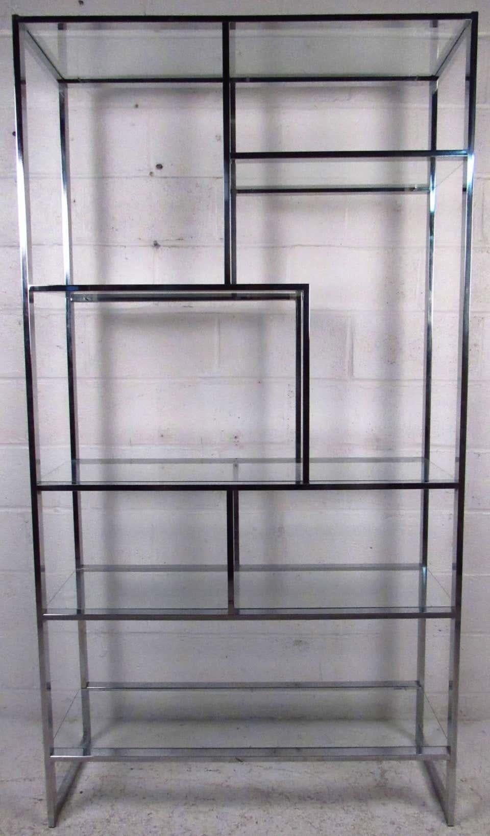 Vintage modern style étagère featuring sculpted chrome body with glass inserts, designed by Design Institute of America. Ideal for any living room or store display this shelving unit adds a brilliant boost of sophistication to any space. While