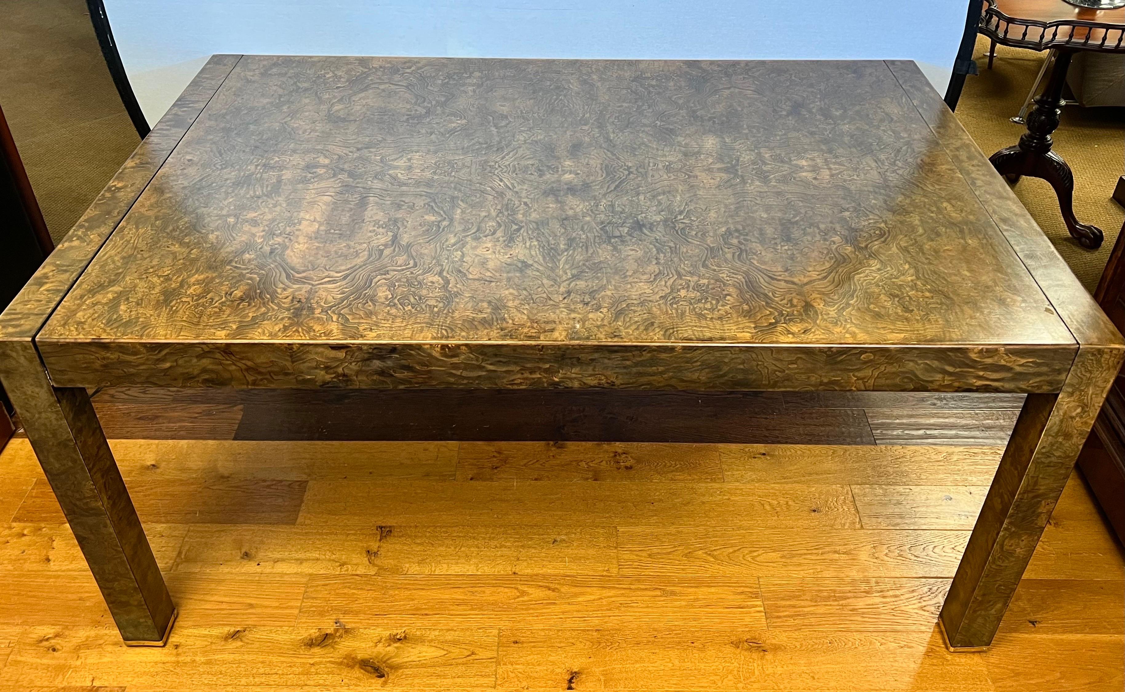 Impressive Mid-Century modern burled olive wood, expandable Parsons dining table. Beautiful burl laminate veneer wraps around the entire table top and legs with intricate burl detail and smooth clean lines characteristic of classic mid century