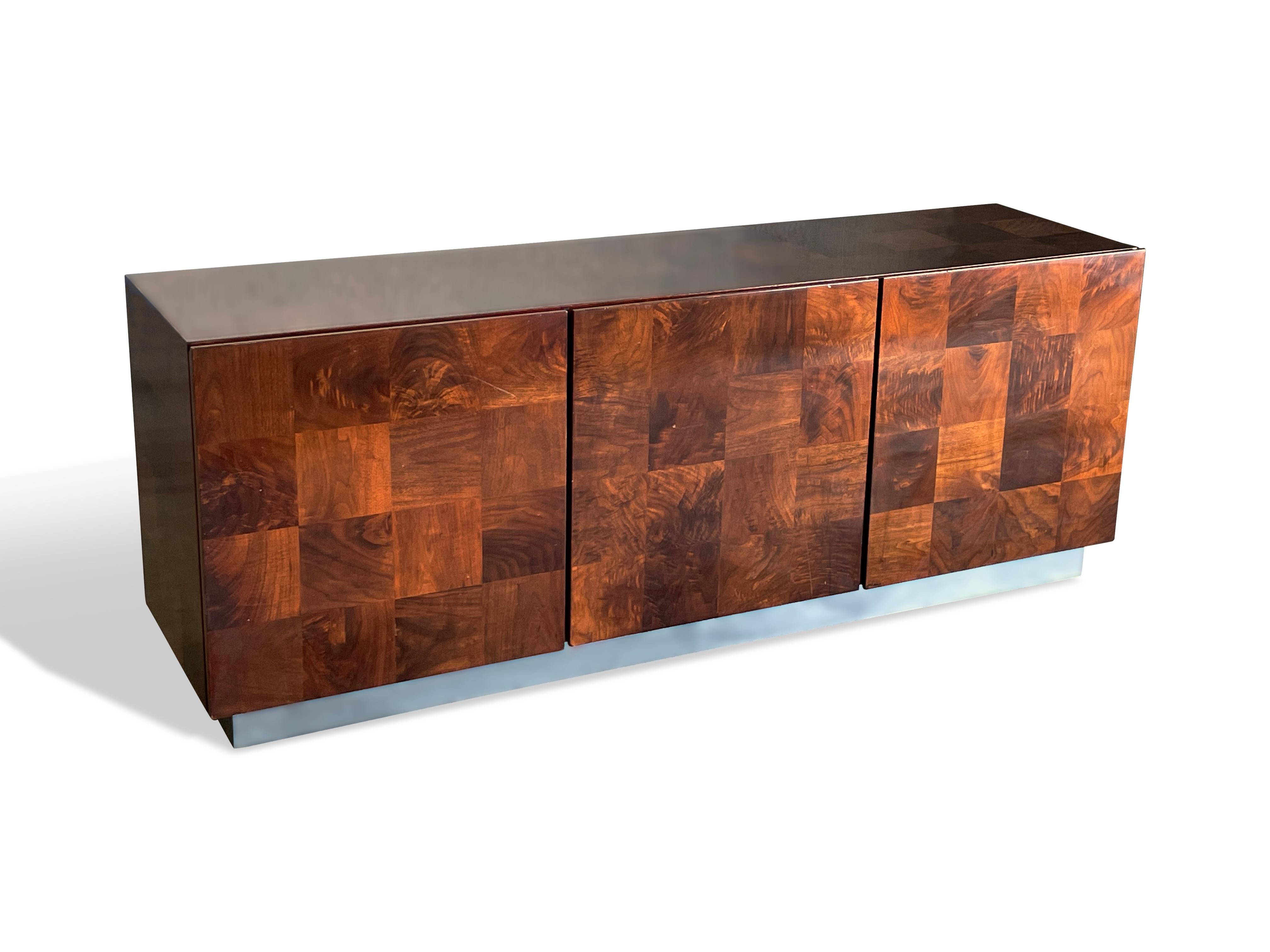 Patchwork credenza designed by Milo Baughman for Thayer Coggin 1970s
Burl wood in walnut with high gloss finish on a chrome plinth base
Left side features 4 drawers with two upper felt lined and a right side adjustable shelf
Signed to drawer interior