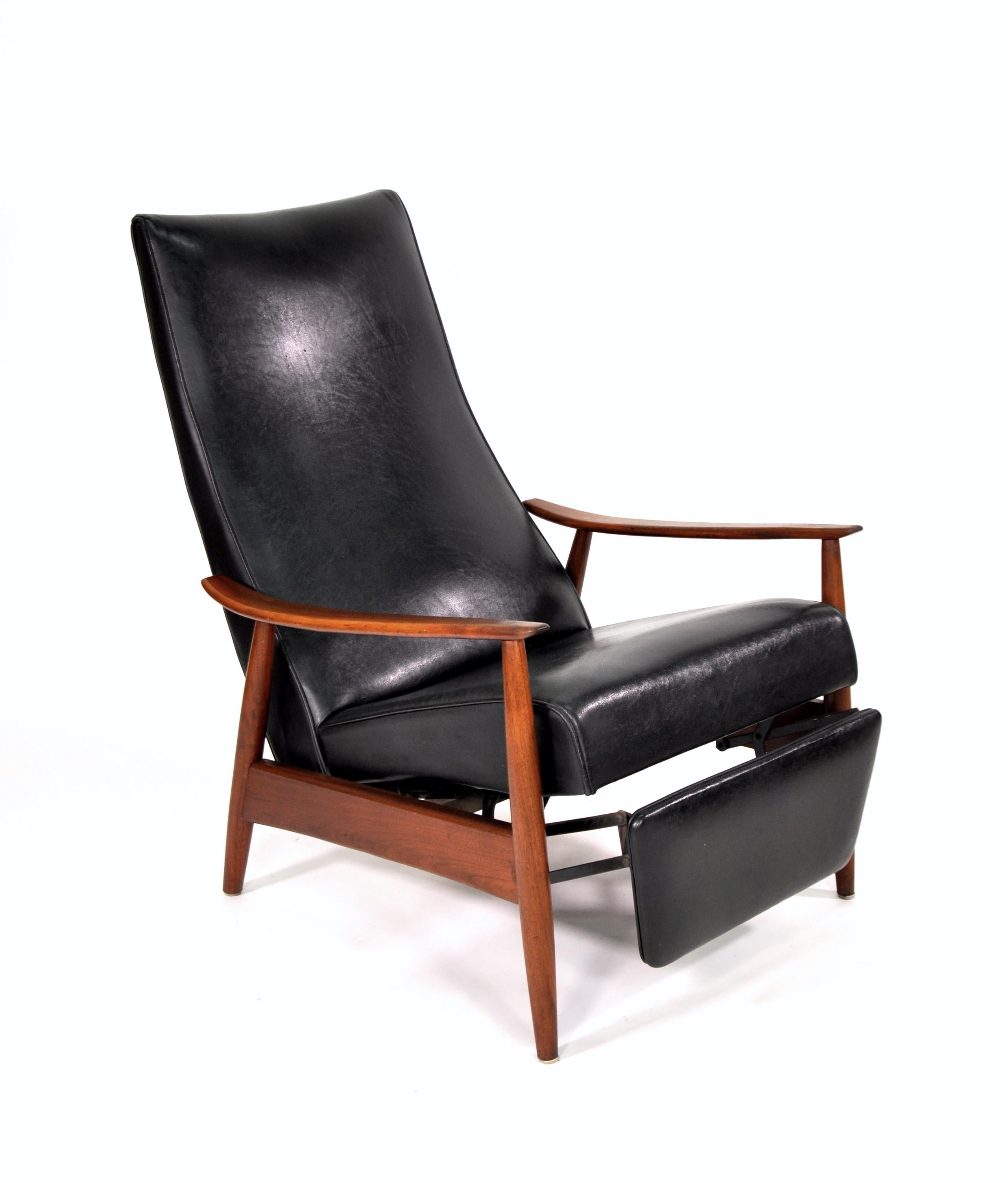 A vintage example of Milo Baughman's Mid-Century Modern 74 reclining armchair. It features an amazing, sculptural solid walnut frame and the original black vinyl upholstery. The chair has a high back and is very comfortable, as all its proportions