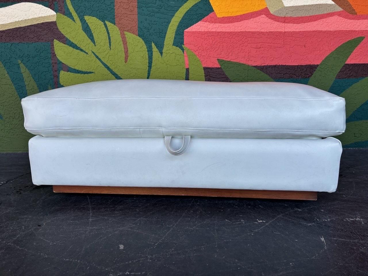 Pouf portaoggetti oversize di metà secolo in vinile bianco su una base di legno con rotelle nascoste. Il coperchio si apre per rivelare un ampio spazio nascosto. Conserva l'etichetta originale di Thayer Coggin sotto la maniglia nella parte inferiore